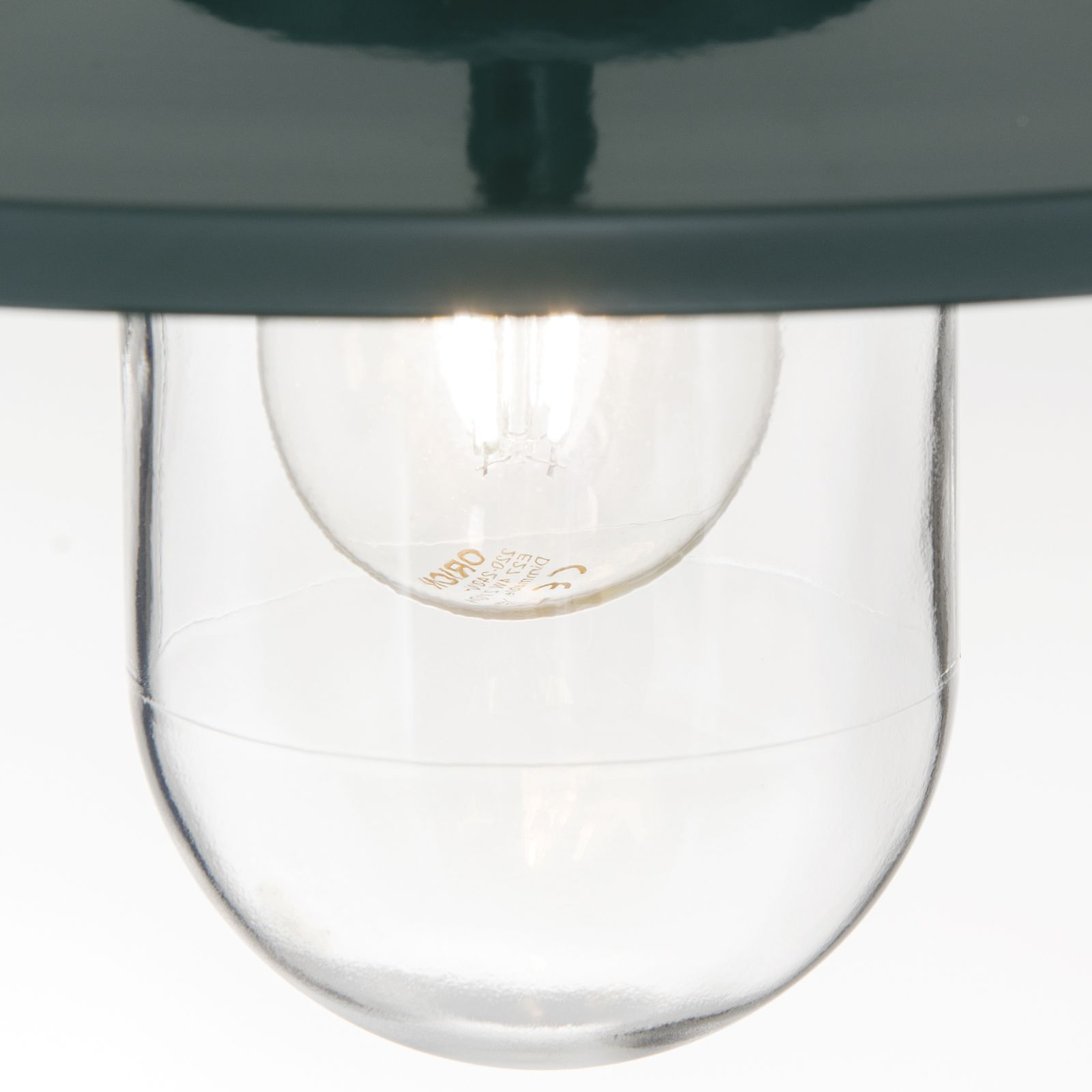 Nahaufnahme einer brennenden Glühbirne in einem klaren Glasschirm.
