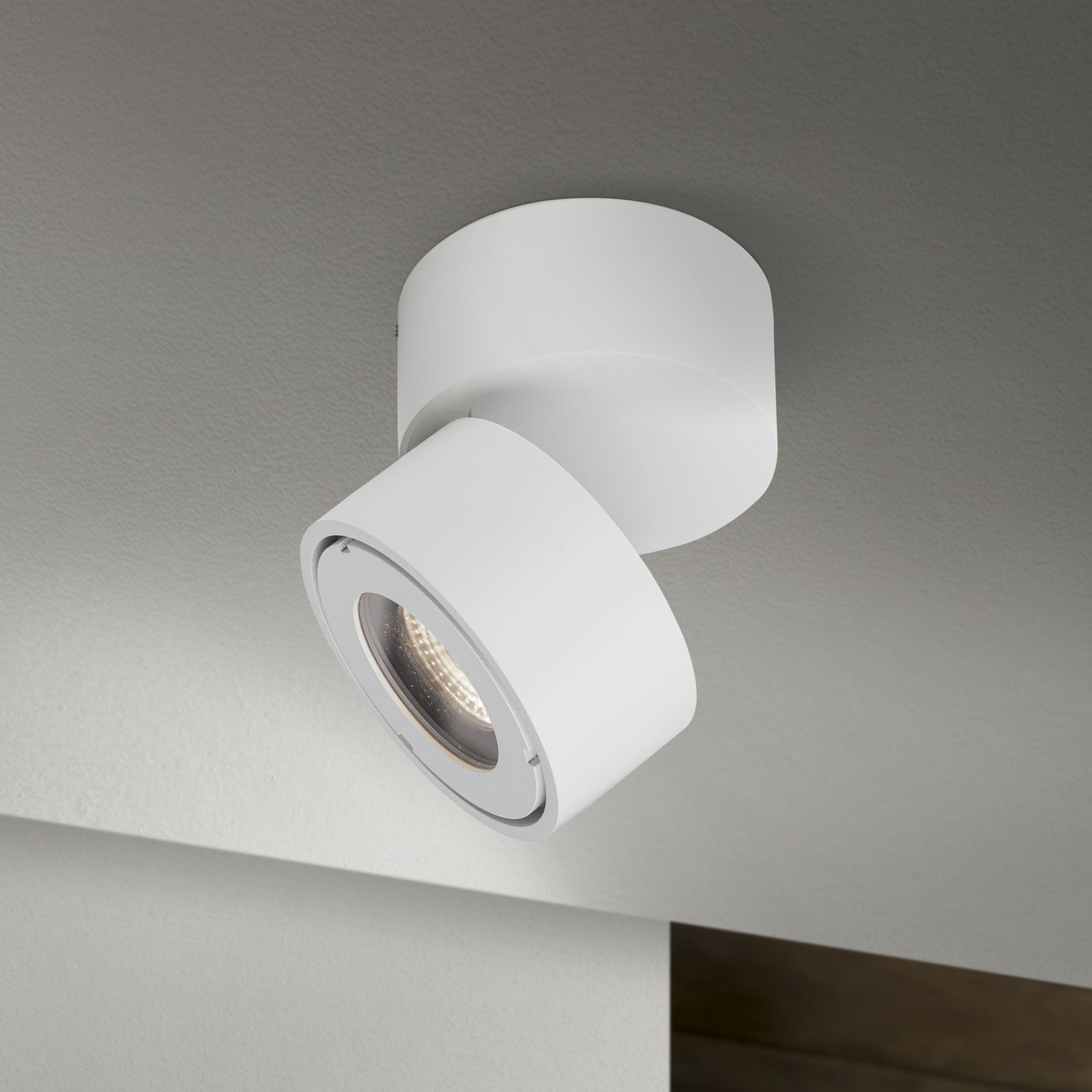 Eine moderne weiße Deckenleuchte montiert an einer weißen Decke.