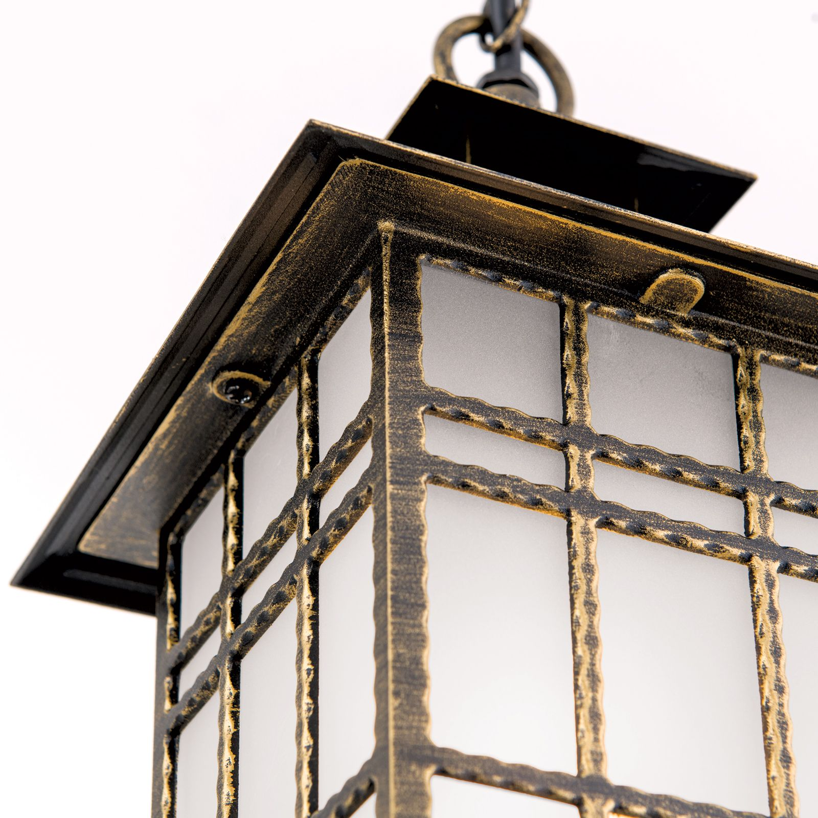 Eine schwarze und goldene Laterne mit mattem Glas hängt an einer Kette.