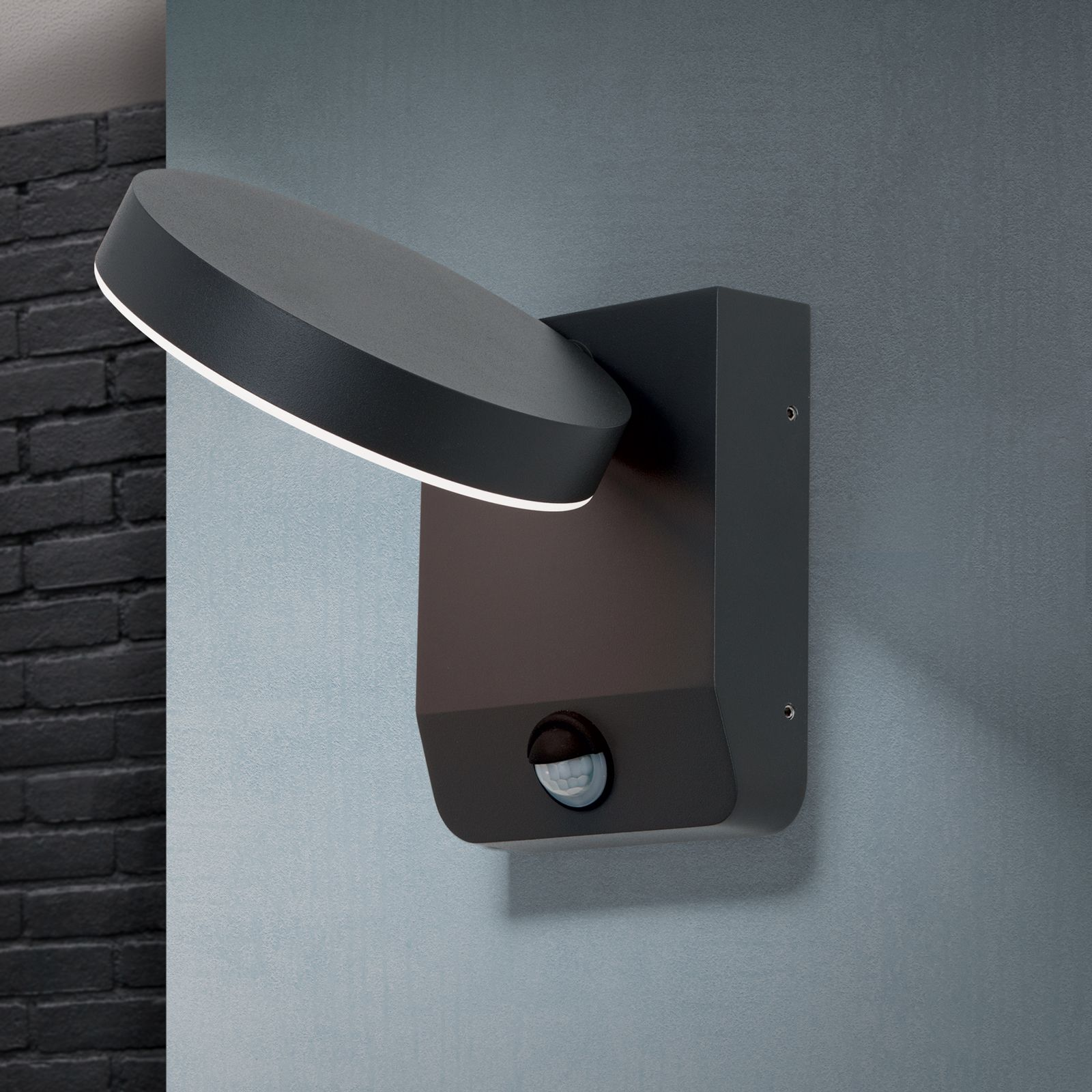 Moderne schwarze LED-Wandleuchte mit Sensor an einer grauen Wand.