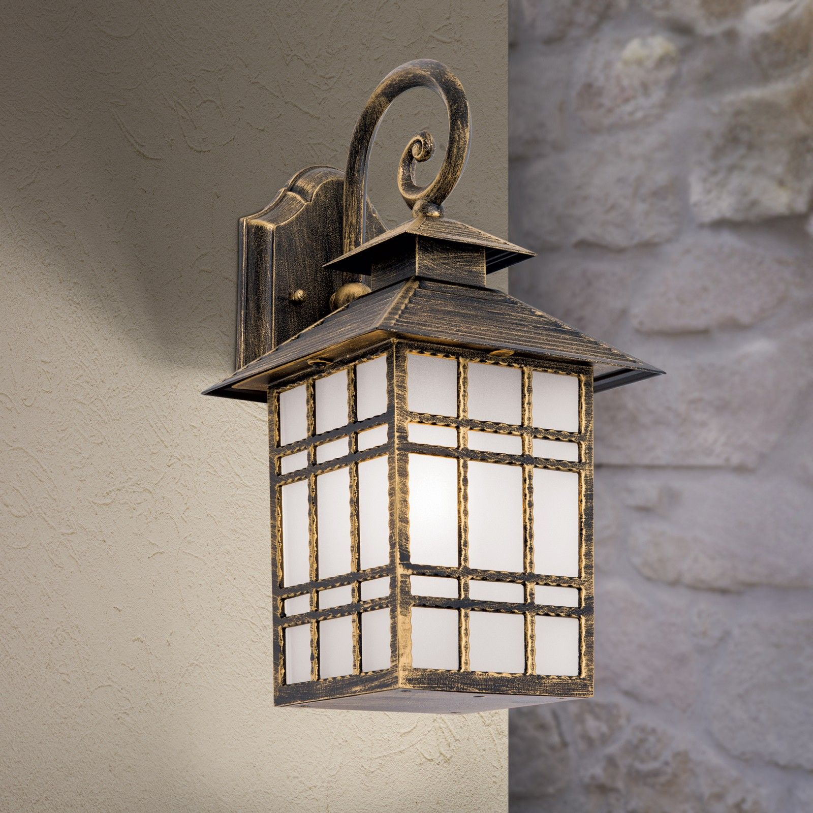 Eine rustikale Wandlampe mit dunklem Metallrahmen und mattem Glas an einer Außenwand.
