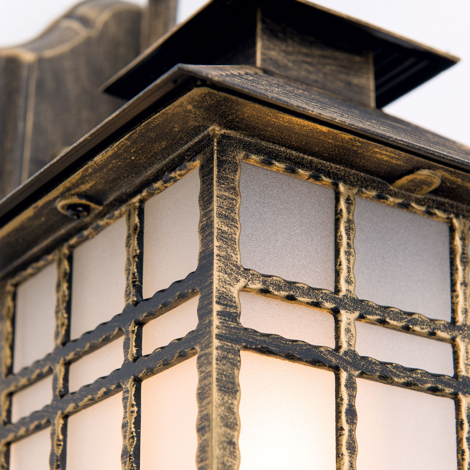 Antike Wandlaterne aus Metall mit strukturiertem Glas und gold-schwarzem Finish.