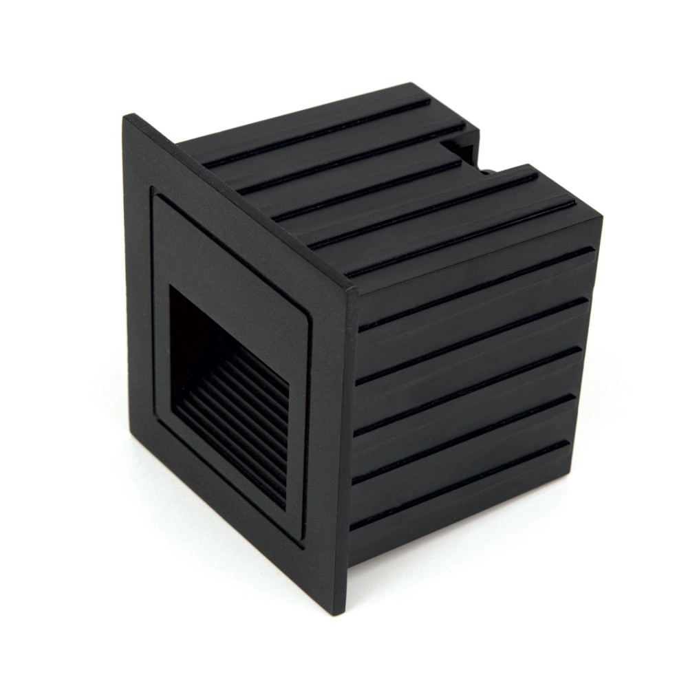 Eine schwarze Wandeinbauleuchte mit geripptem Korpus und quadratischer Frontplatte vor weißem Hintergrund.