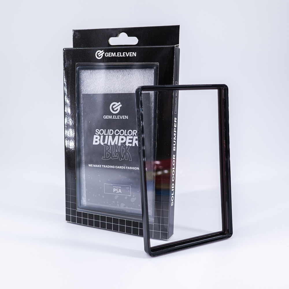 Schwarze Verpackung mit der Aufschrift GEM.ELEVEN und ein passender schwarzer Rahmen vor einem hellen Hintergrund.