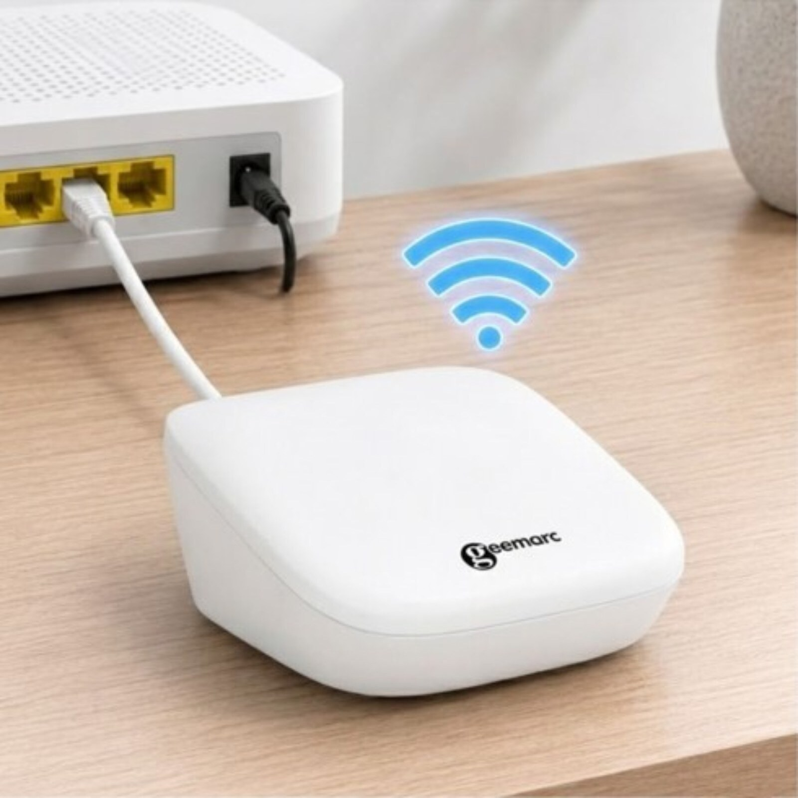 Ein weißer Geemarc WLAN-Verstärker auf einem Holzschreibtisch, verbunden mit einem Router.