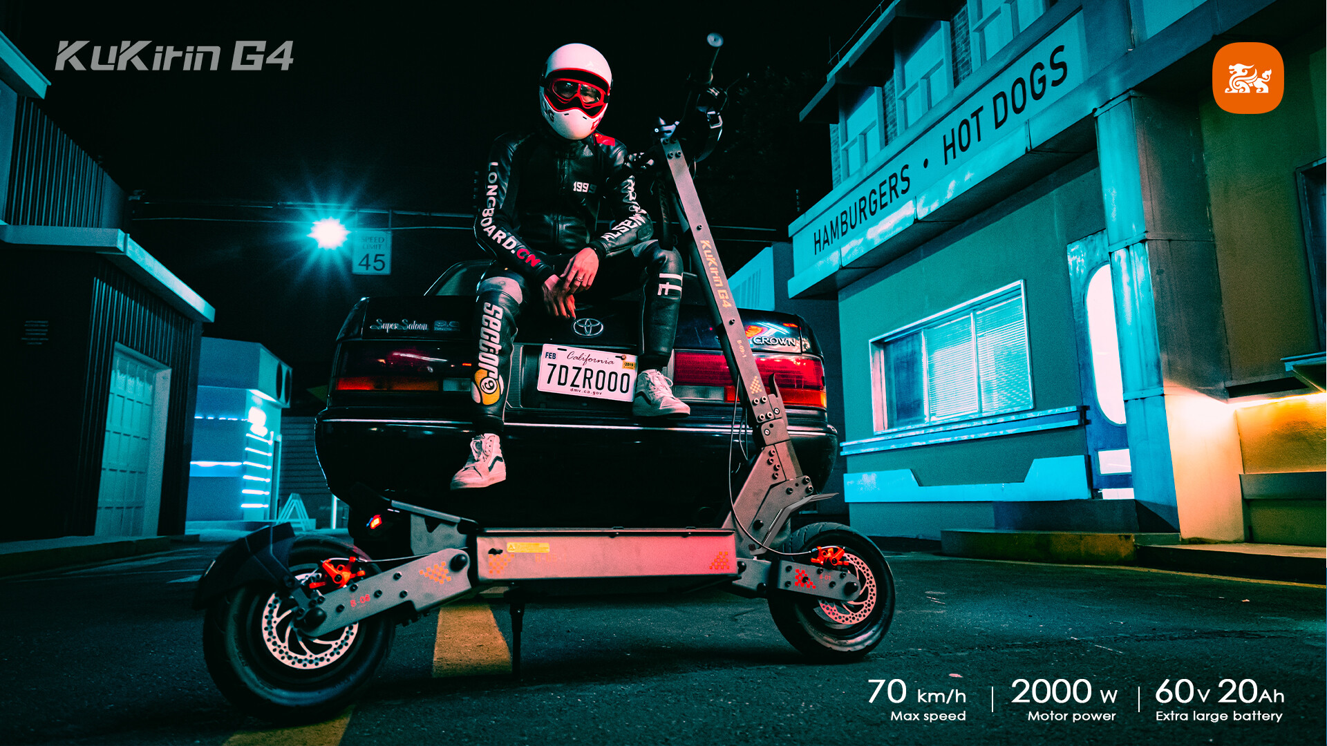 Un motociclista con casco siede su un'auto di notte vicino a una tavola calda con monopattino elettrico.
