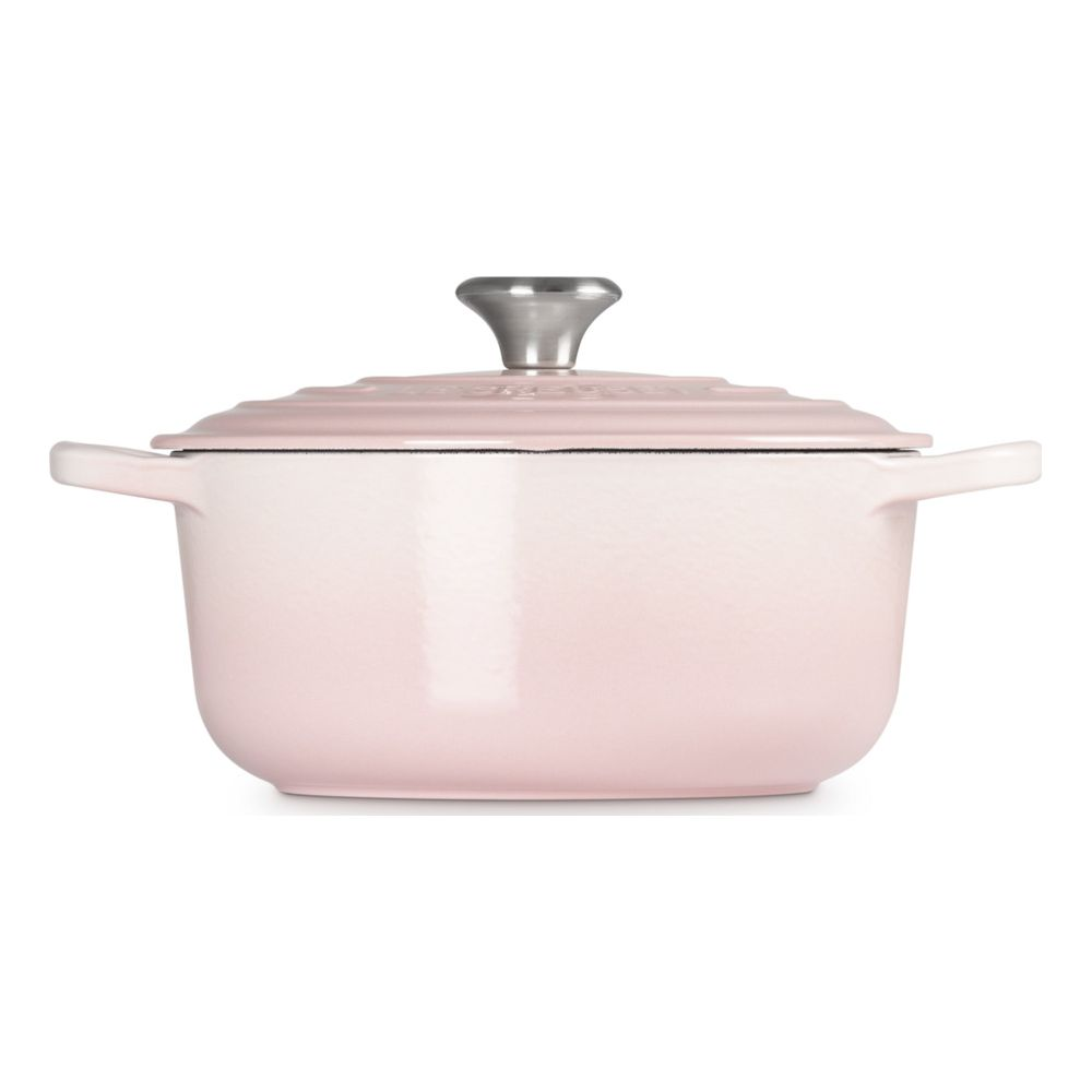 Une cocotte rose pastel avec un bouton argenté sur fond blanc.