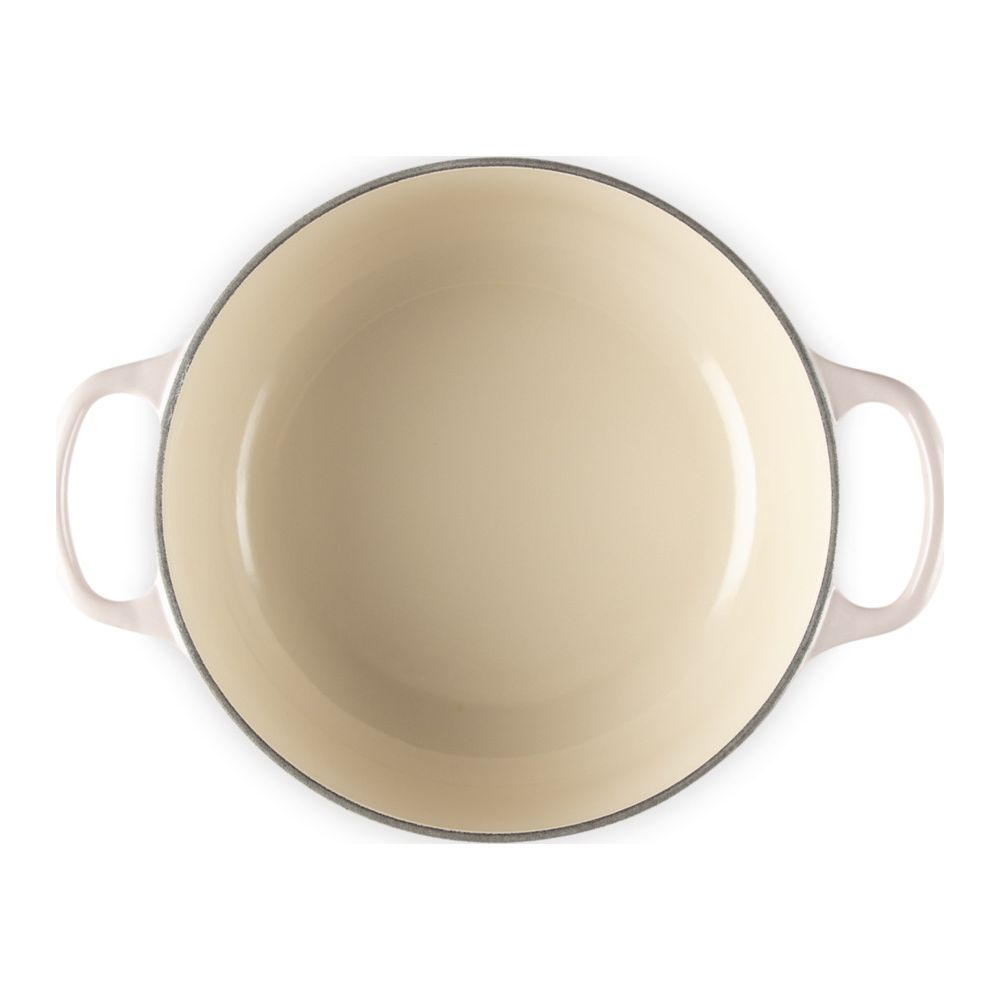 Une cocotte ronde en fonte de couleur crème avec deux poignées latérales sur fond blanc.