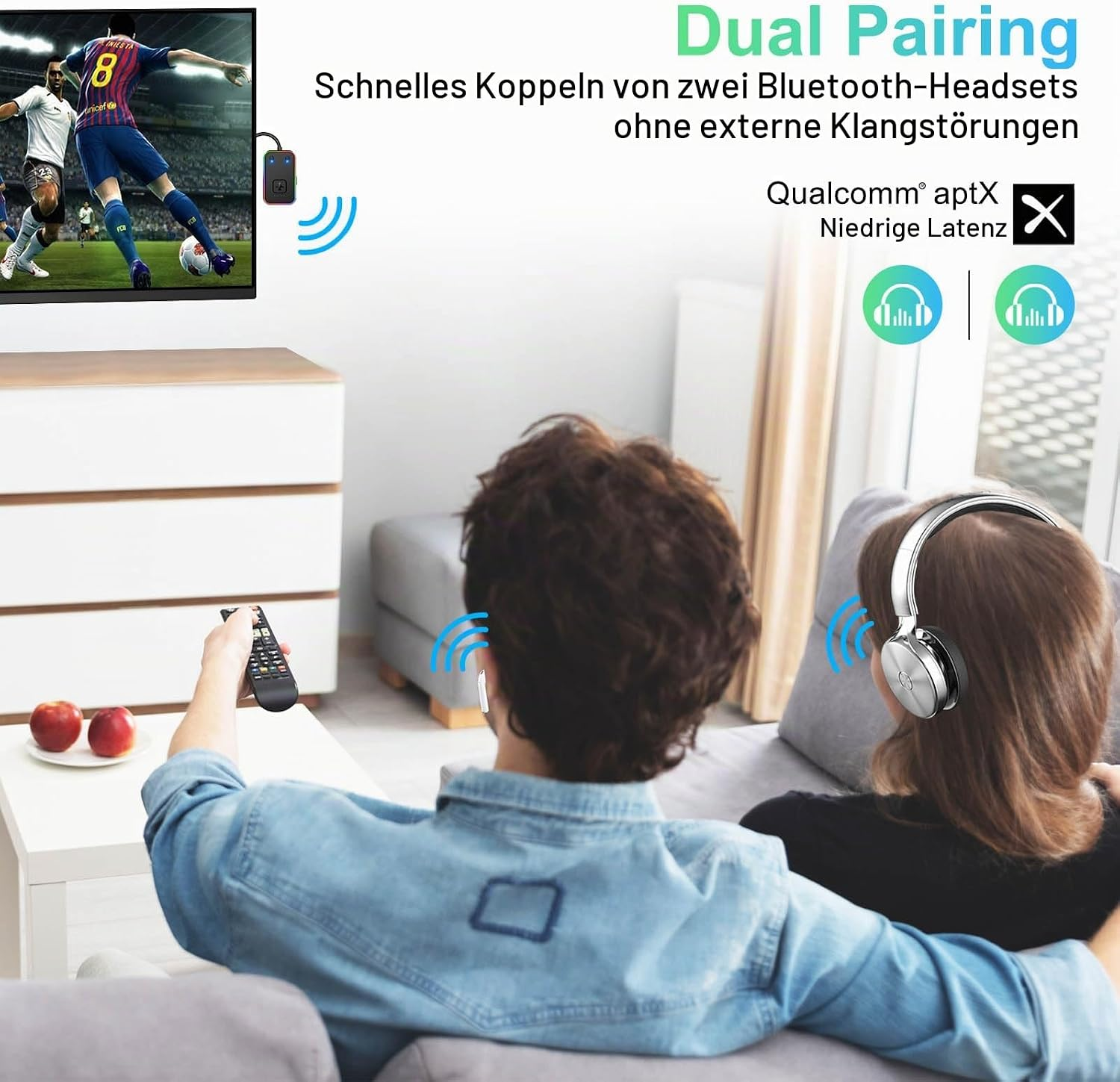 Ein Paar sitzt auf dem Sofa und schaut TV, verbunden mit zwei Headsets.