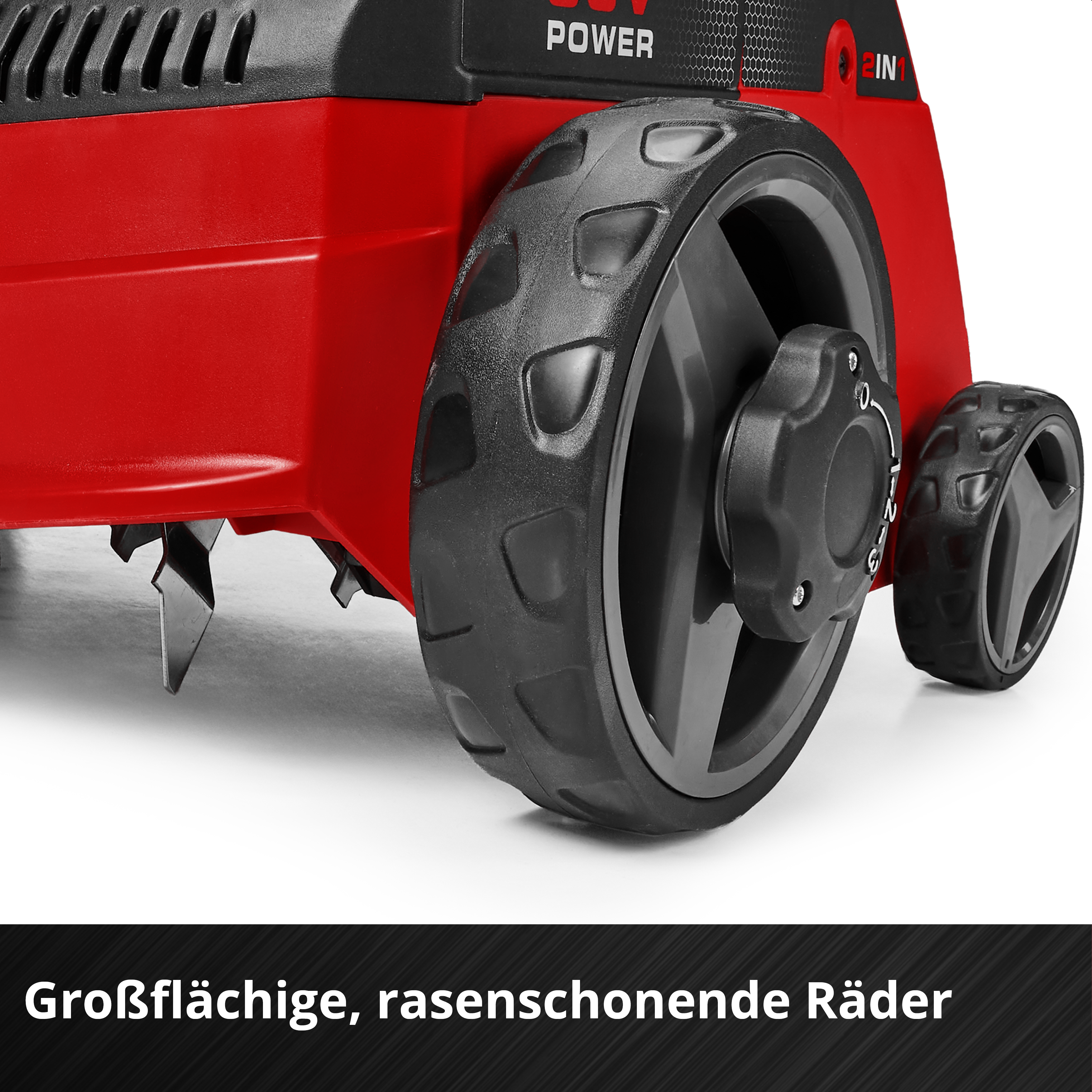Nahaufnahme großer Kunststoffräder und Messer eines roten und schwarzen Vertikutierers auf weißem Hintergrund.