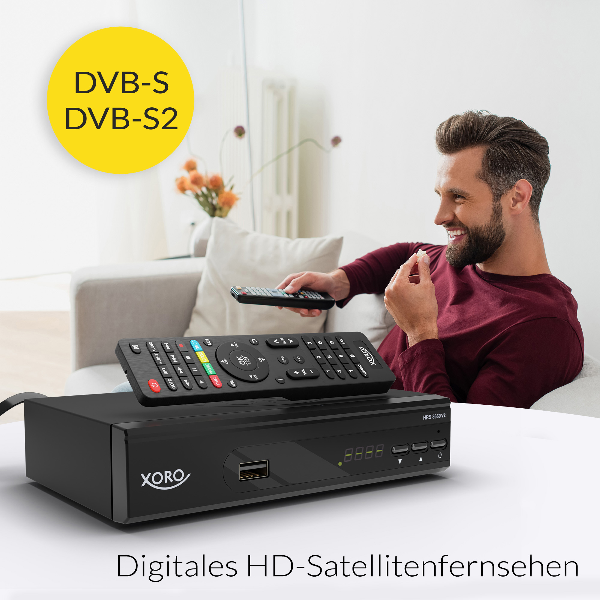 Ein lächelnder Mann auf dem Sofa, der Popcorn isst, mit Satellitenreceiver und Fernbedienung im Vordergrund.