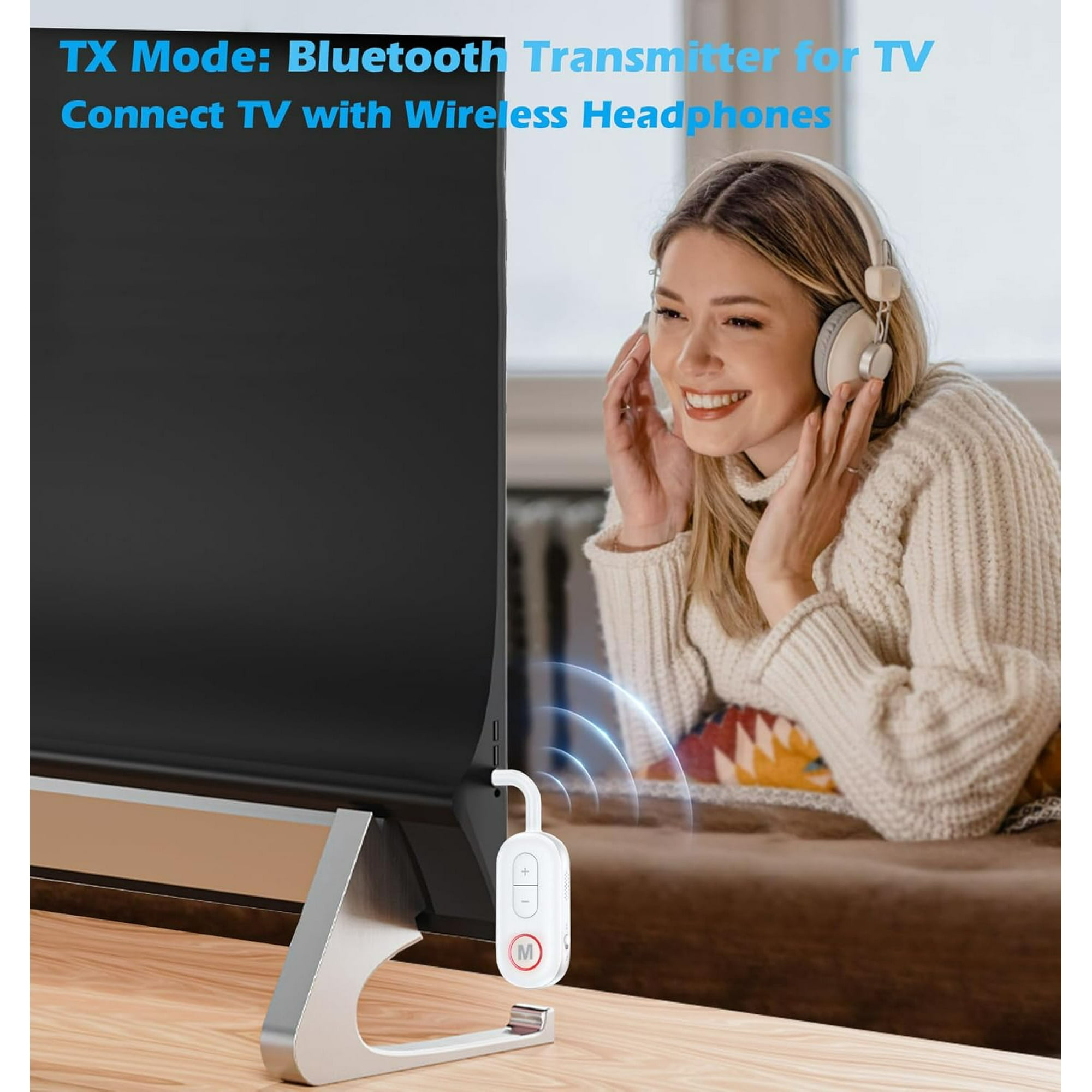 Eine lächelnde Frau mit Kopfhörern sitzt vor einem Fernseher mit einem Bluetooth-Sender.