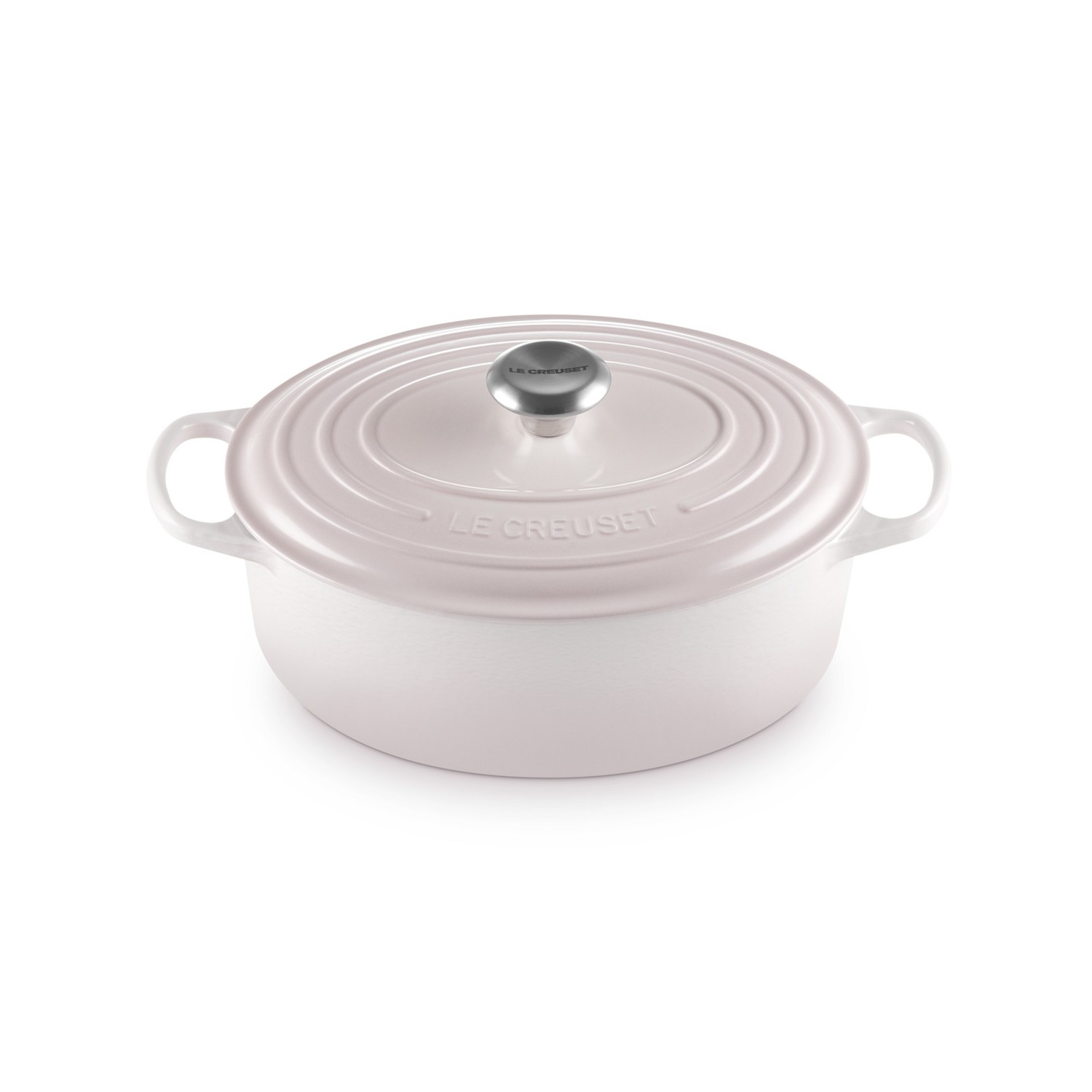 Cocotte ovale en fonte Le Creuset rose clair avec couvercle et bouton en métal sur fond blanc.