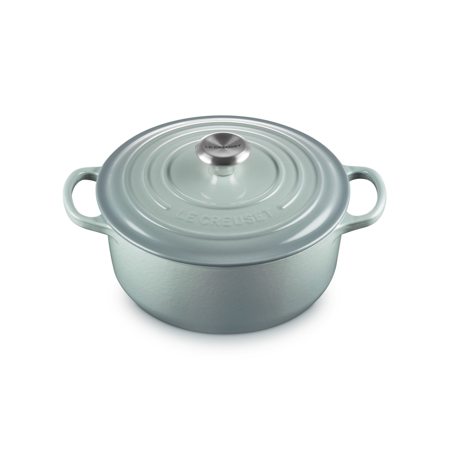 Une cocotte en fonte Le Creuset bleu clair avec un bouton argenté sur fond blanc.
