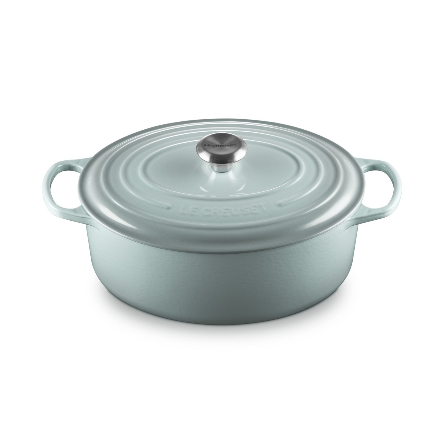 Une cocotte en fonte Le Creuset bleu clair avec un bouton argenté sur fond blanc.