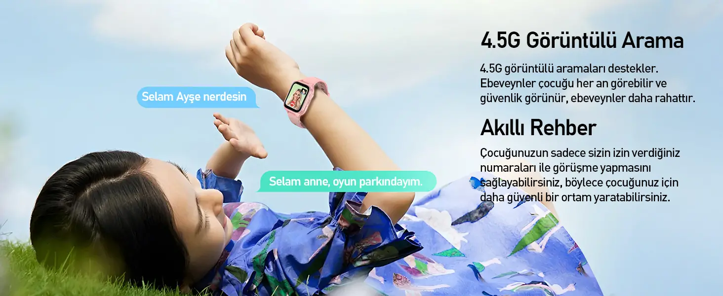 Mavi elbiseli bir çocuk çimlerde yatıyor, bileğinde pembe bir akıllı saat kullanıyor.