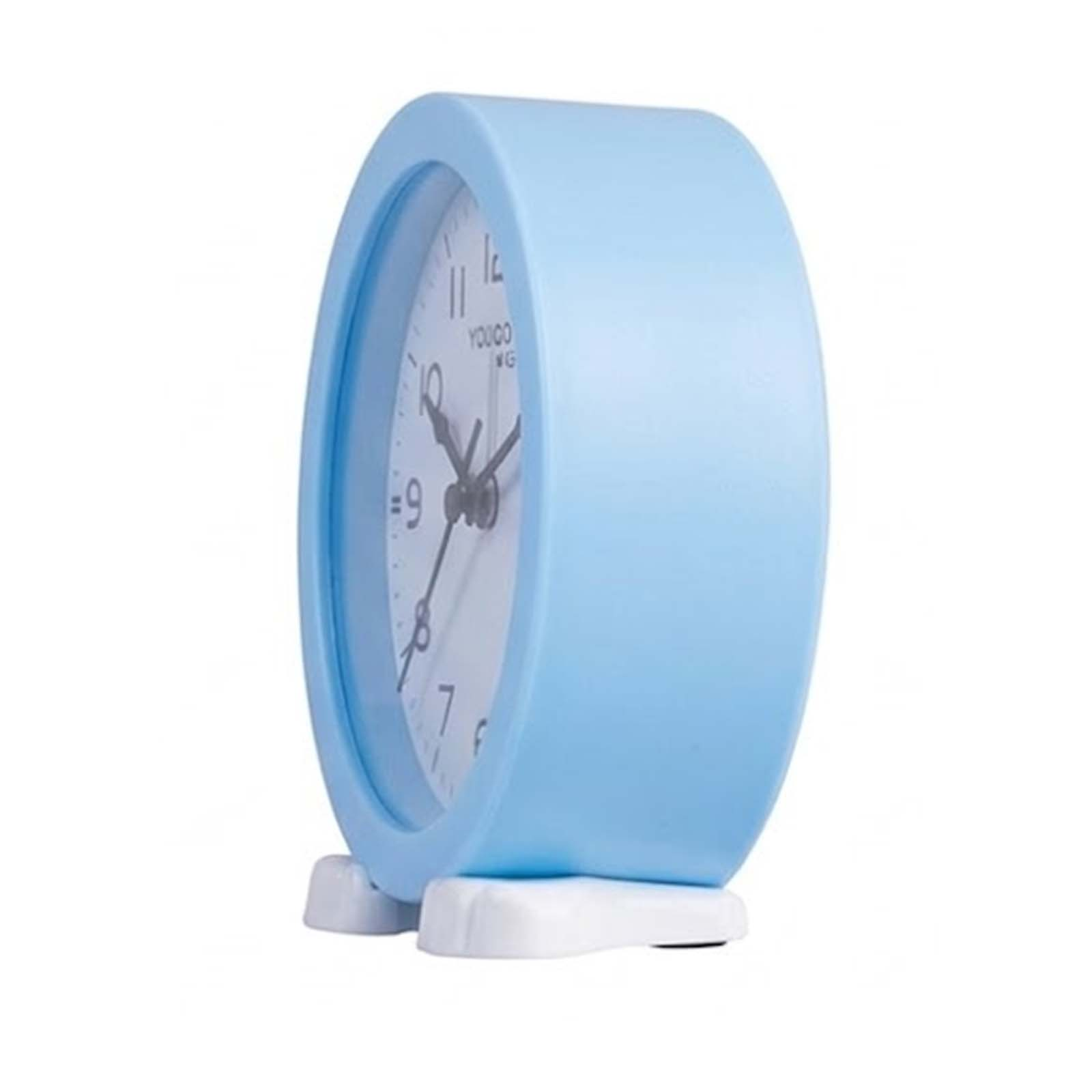 Un reloj de mesa azul claro con esfera blanca y patas blancas sobre un fondo blanco.