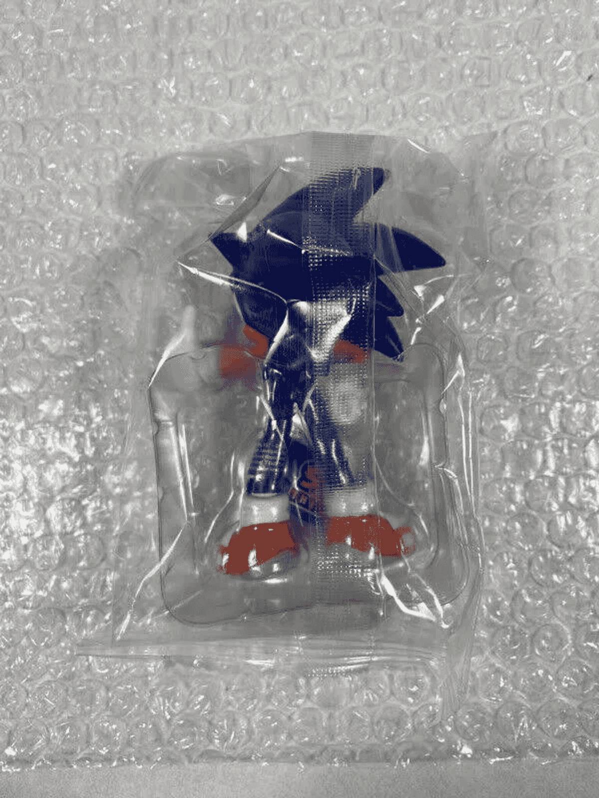 Eine Sonic the Hedgehog Figur in einer versiegelten Plastiktüte auf Luftpolsterfolie.