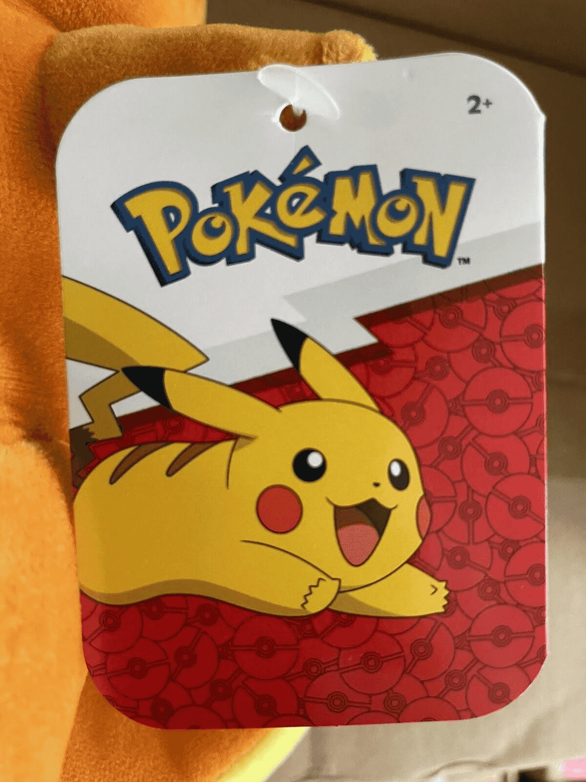 Étiquette Pokémon avec un Pikachu jaune sur fond rouge de Pokéball et le logo.