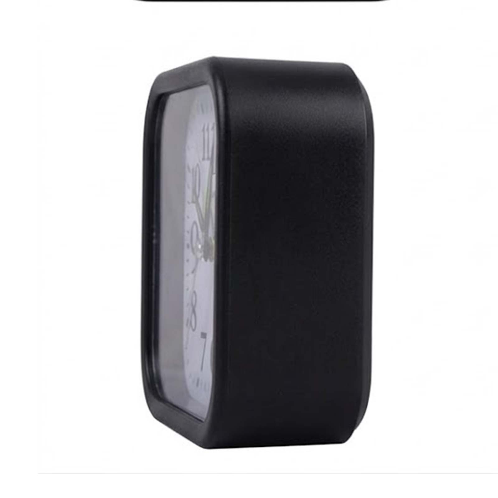 Un reloj de mesa negro y rectangular visto de lado sobre fondo blanco.
