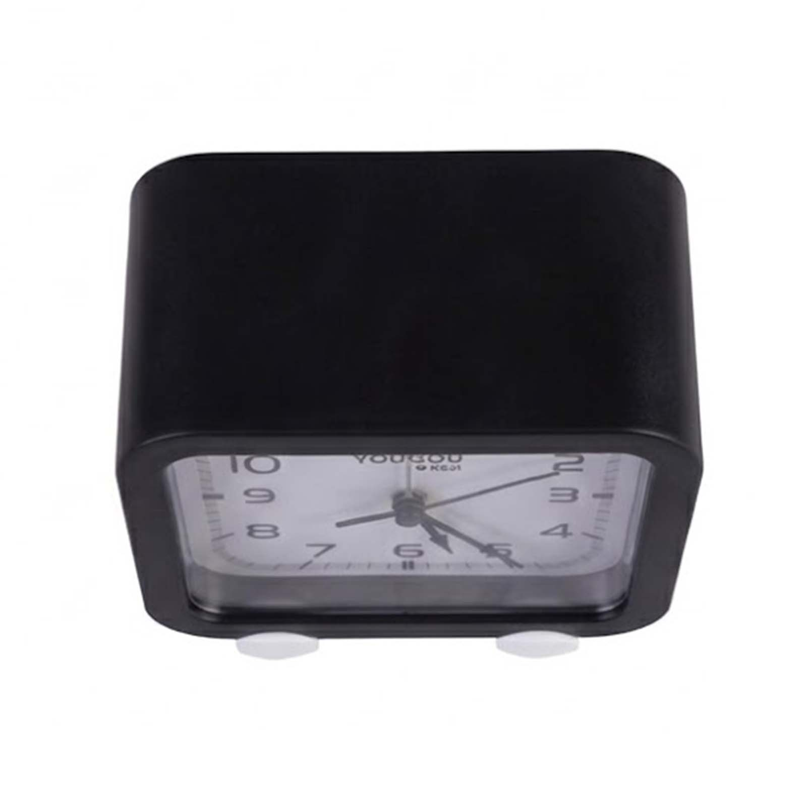 Un pequeño reloj despertador negro de forma cuadrada con esfera blanca sobre un fondo blanco.