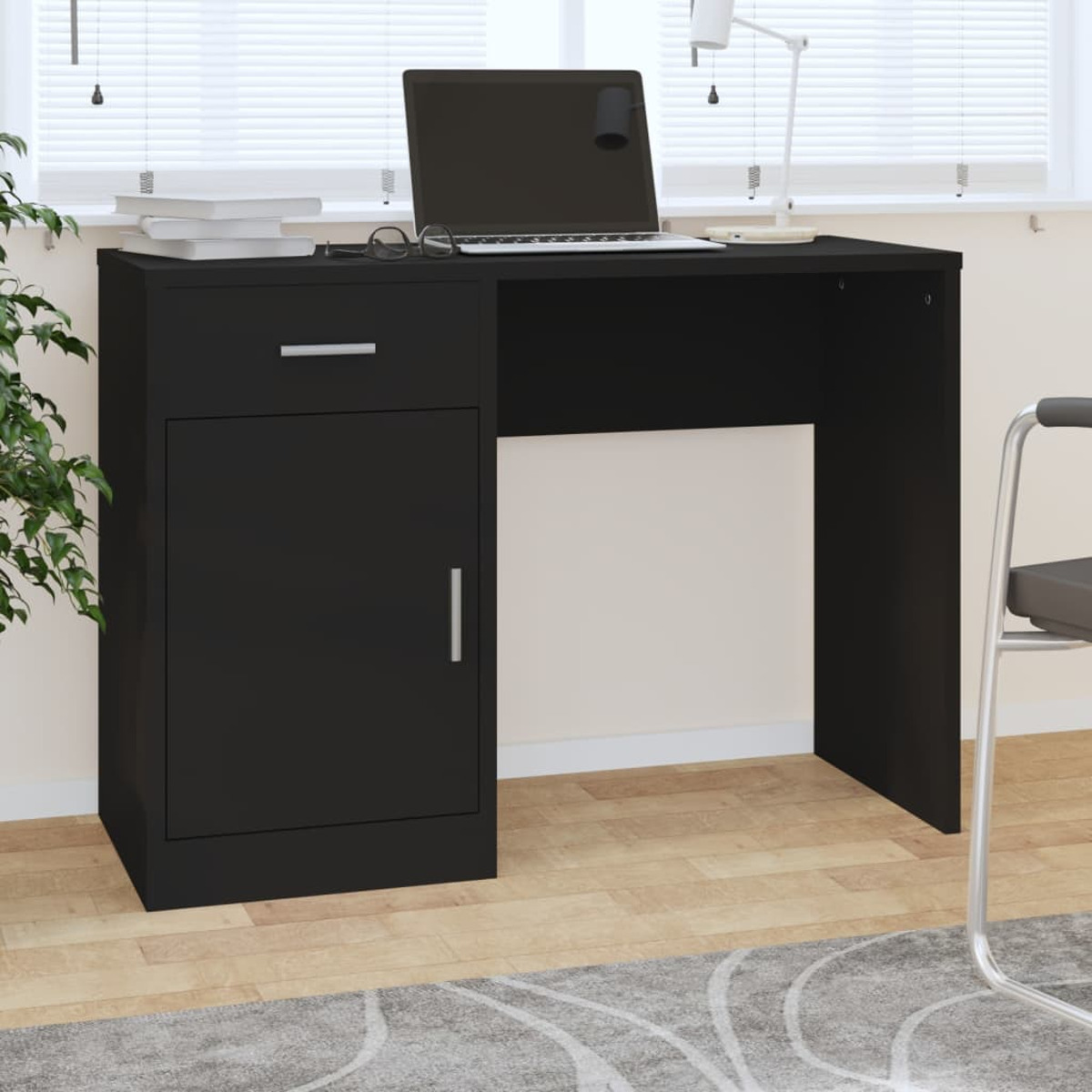 Ein schwarzer Schreibtisch mit Schublade und Schrank steht in einem Raum mit Holzboden und Laptop.