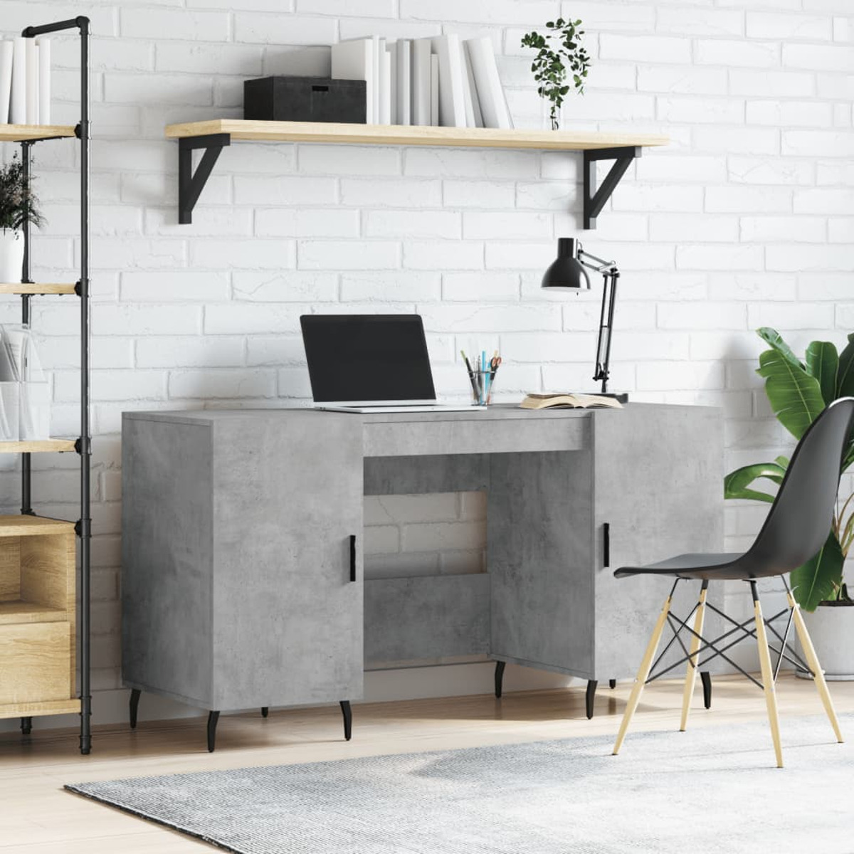 Ein grauer Schreibtisch mit Laptop, Lampe und schwarzem Stuhl vor einer weißen Backsteineinwand.