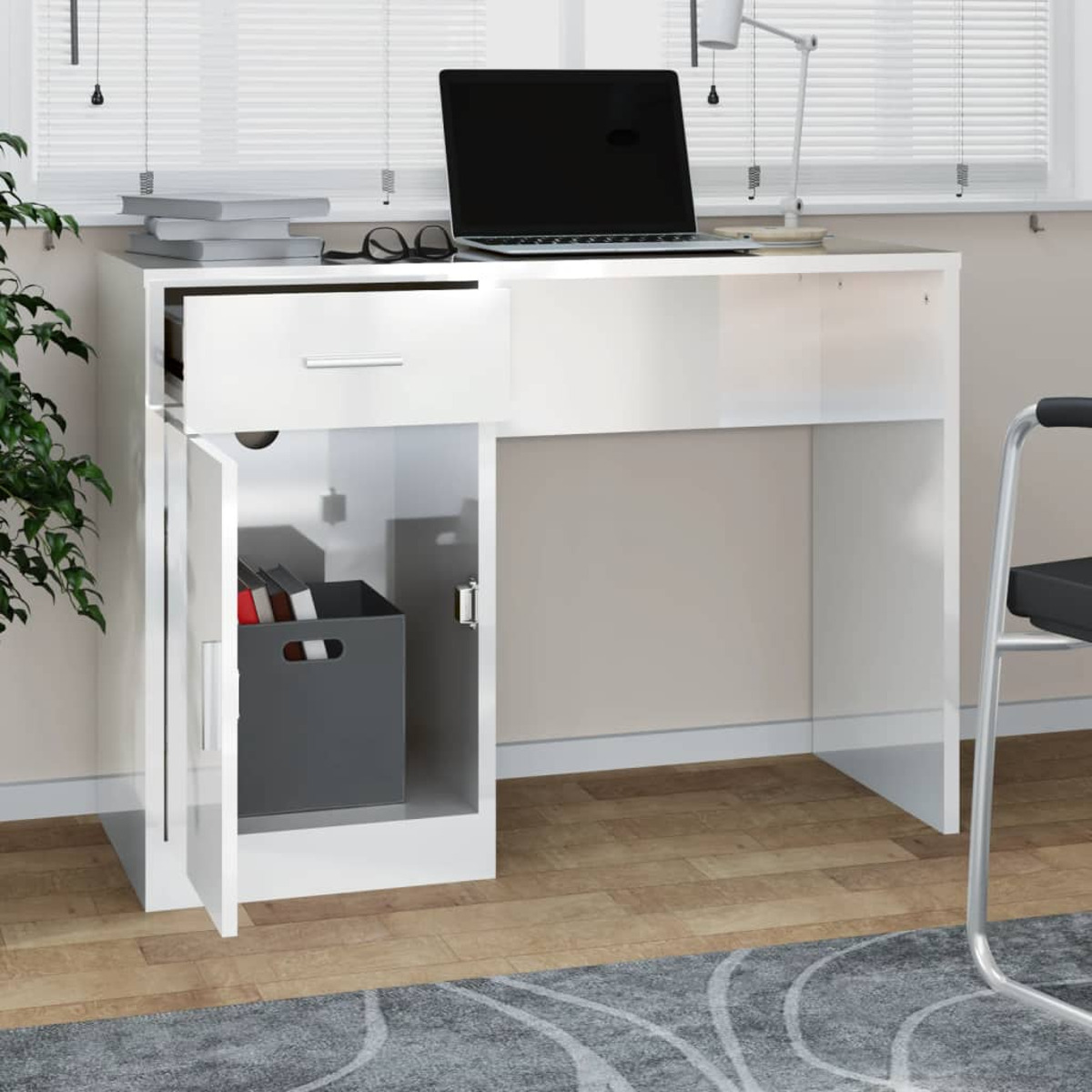 Ein weißer Schreibtisch mit offenem Schrankfach, Schublade, Laptop und Lampe steht in einem Raum.