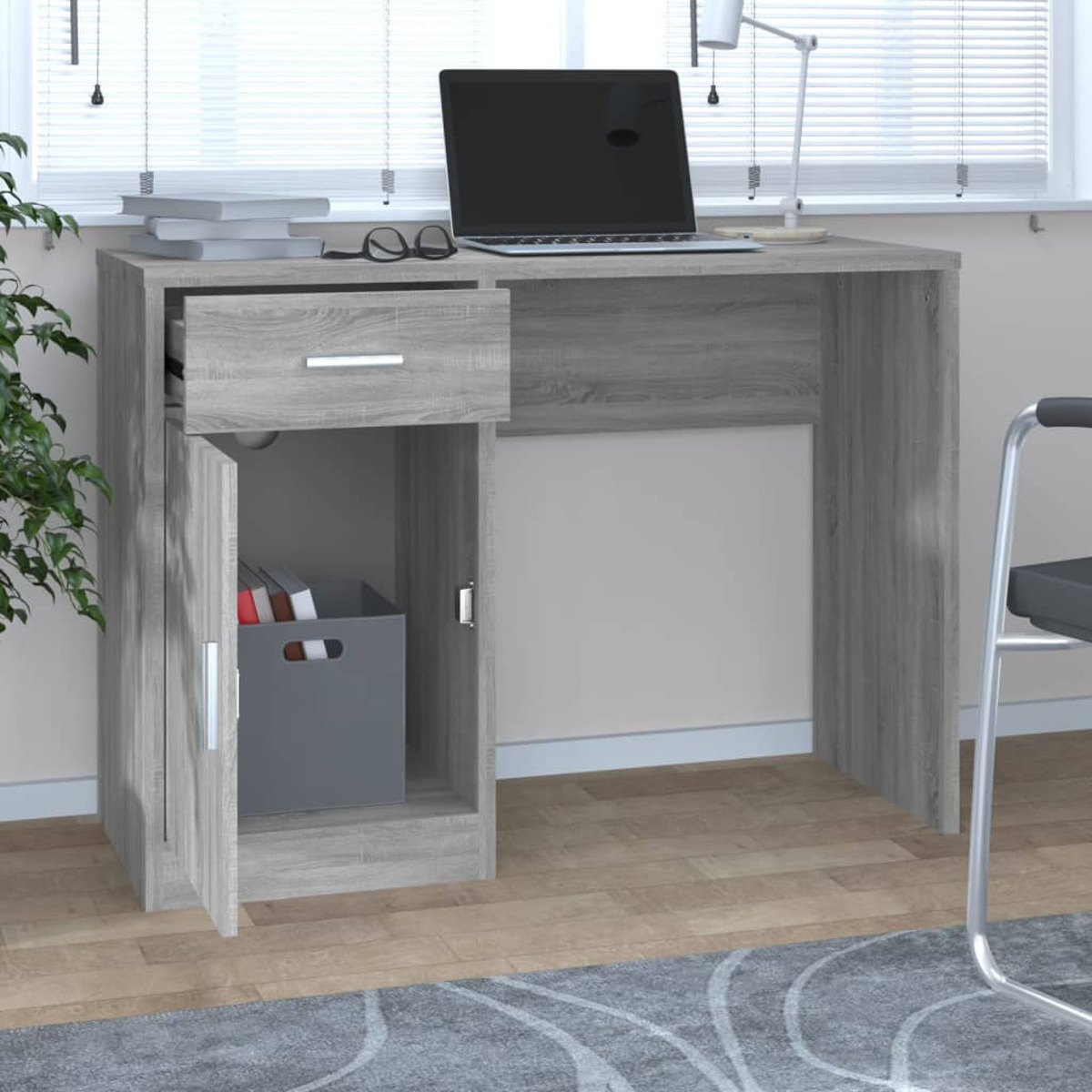 Grauer Holzschreibtisch mit offener Schublade, Schrank mit Kiste, Laptop und Büchern.