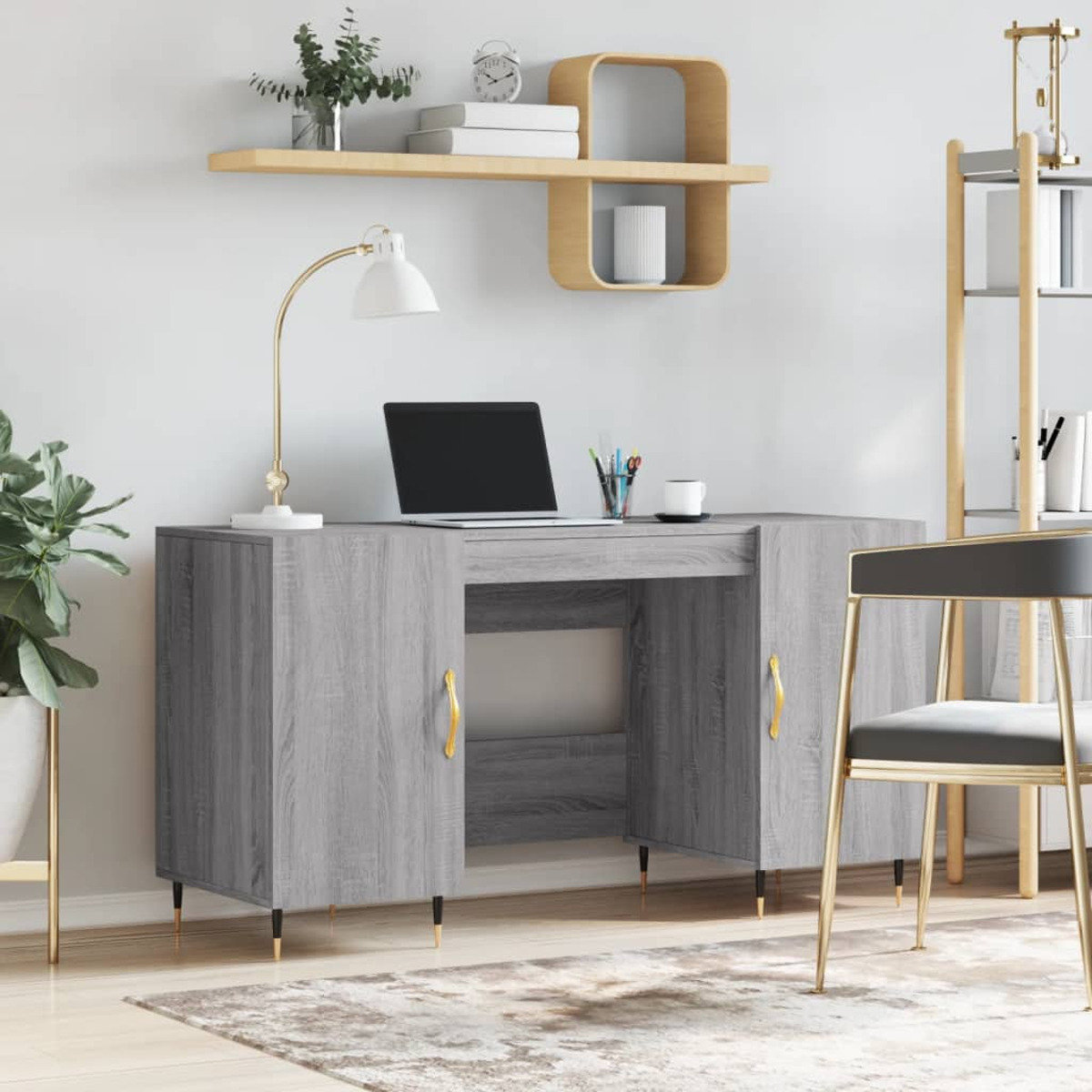 Ein grauer Schreibtisch mit Laptop, Lampe und Regal. Ein Stuhl steht im Vordergrund, eine Pflanze daneben.