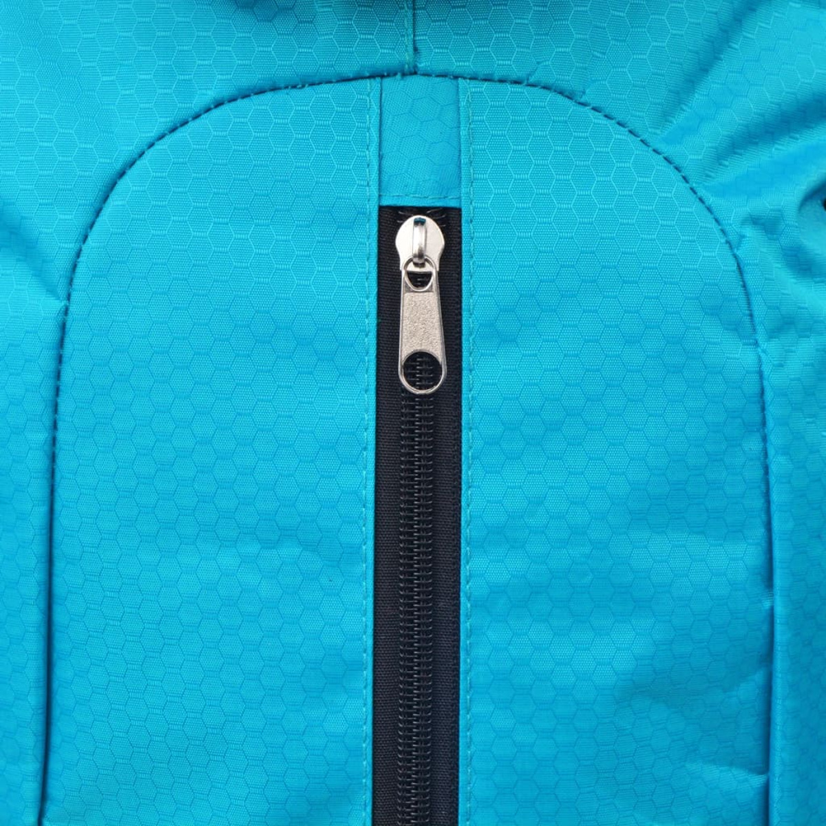 Nahaufnahme eines silbernen Reißverschlusses an einem blauen Stoff mit Wabenmuster.
