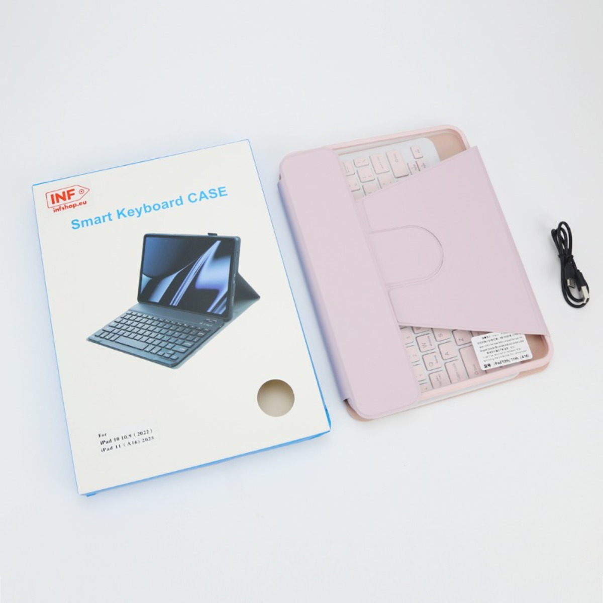 Una custodia con tastiera smart rosa per iPad, la sua scatola e un cavo di ricarica su fondo bianco.