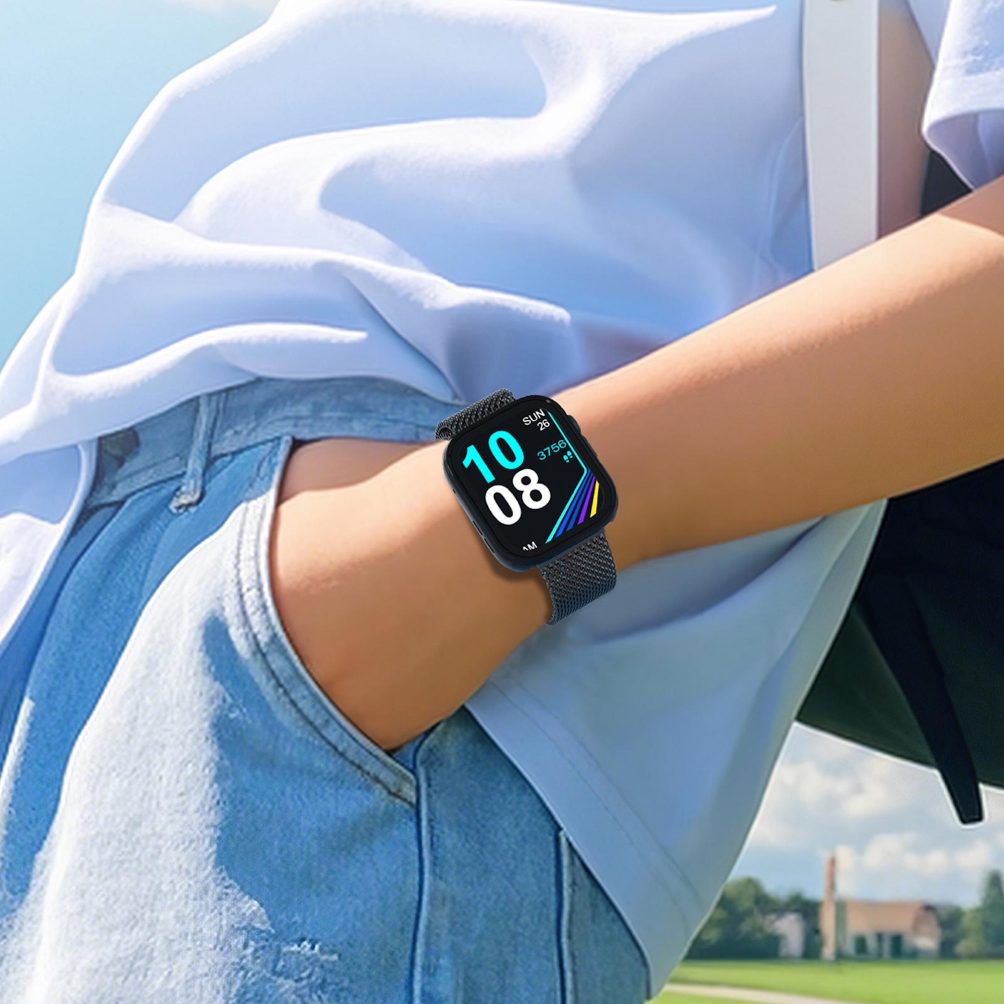 Una persona con camicia azzurra e jeans indossa uno smartwatch nero con display digitale all'aperto.