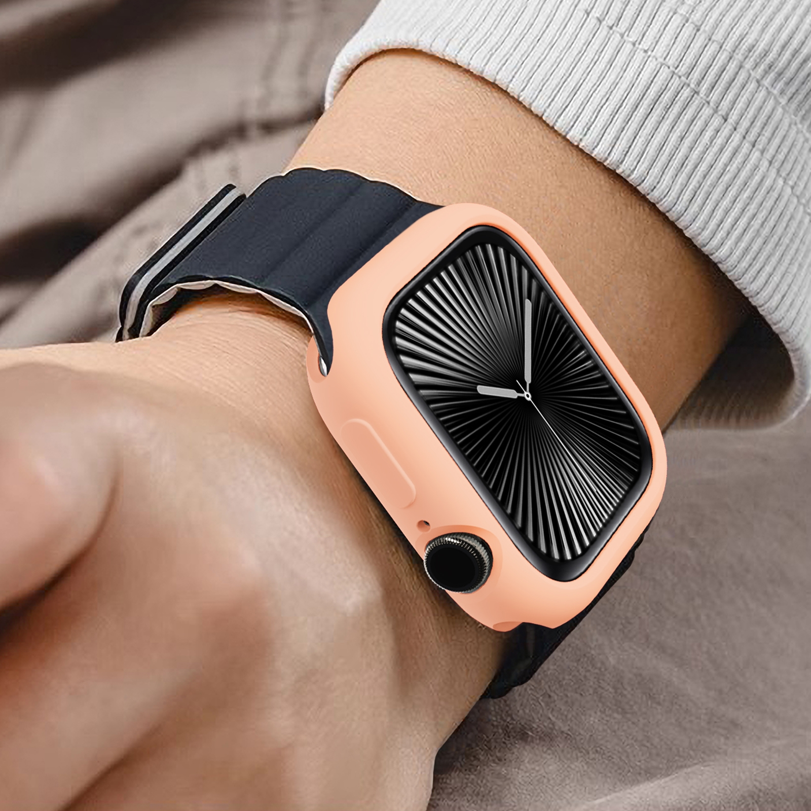 Eine Smartwatch mit pfirsichfarbenem Gehäuse und schwarzem Armband an einem Handgelenk.