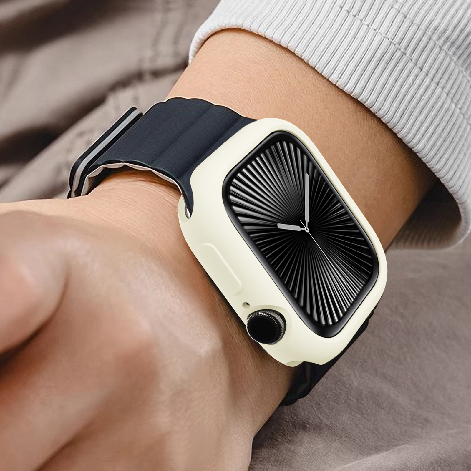 Eine Smartwatch mit beigem Schutzgehäuse und schwarzem Armband wird am Handgelenk getragen.