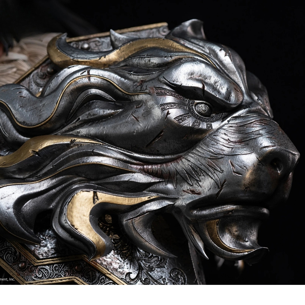 Intrikat gestalteter silberner und goldener Löwenkopf aus Metall mit Kampfkratzern vor dunklem Hintergrund.