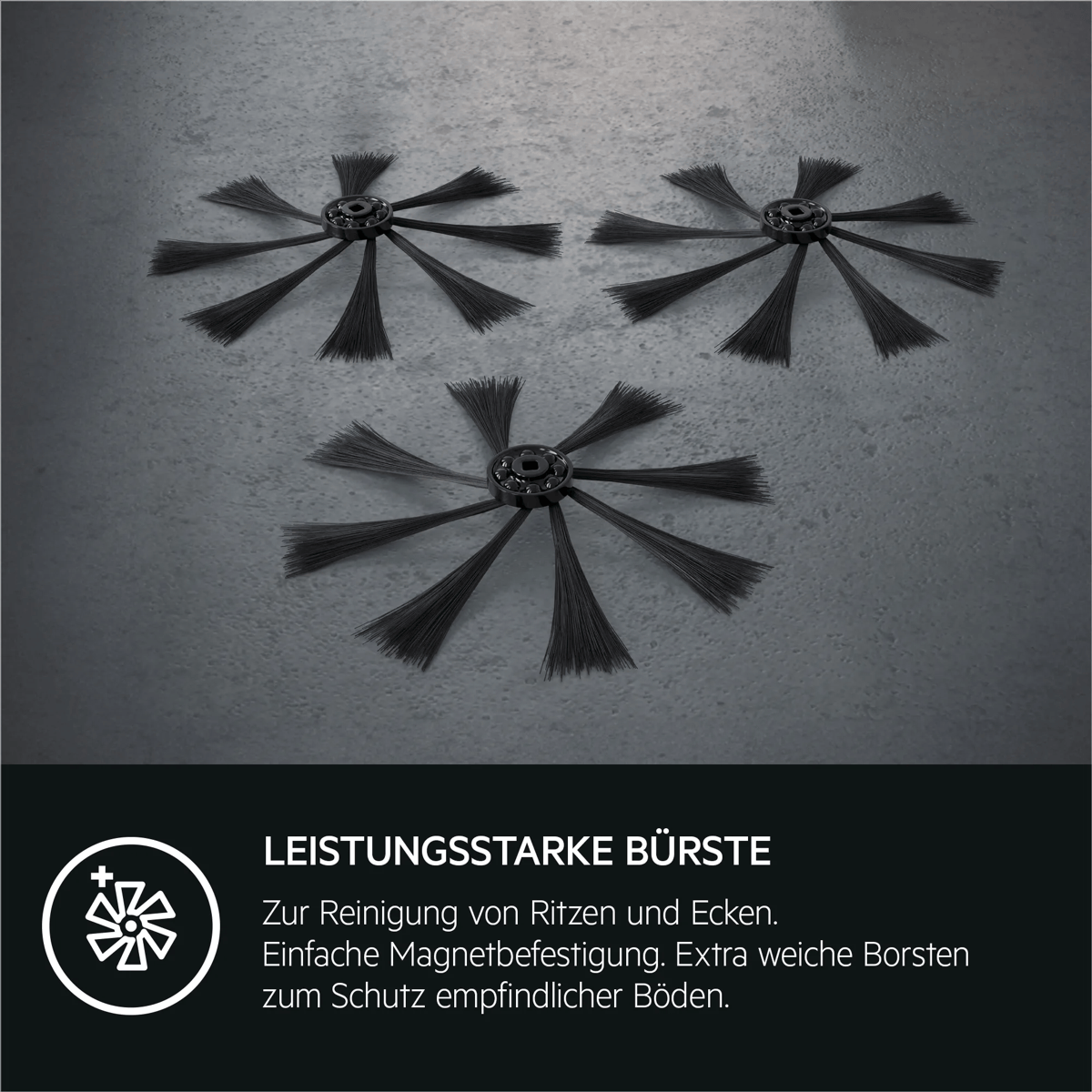 Drei schwarze Roboterstaubsauger-Seitenbürsten auf grauem Boden mit Text über starke Bürsten.