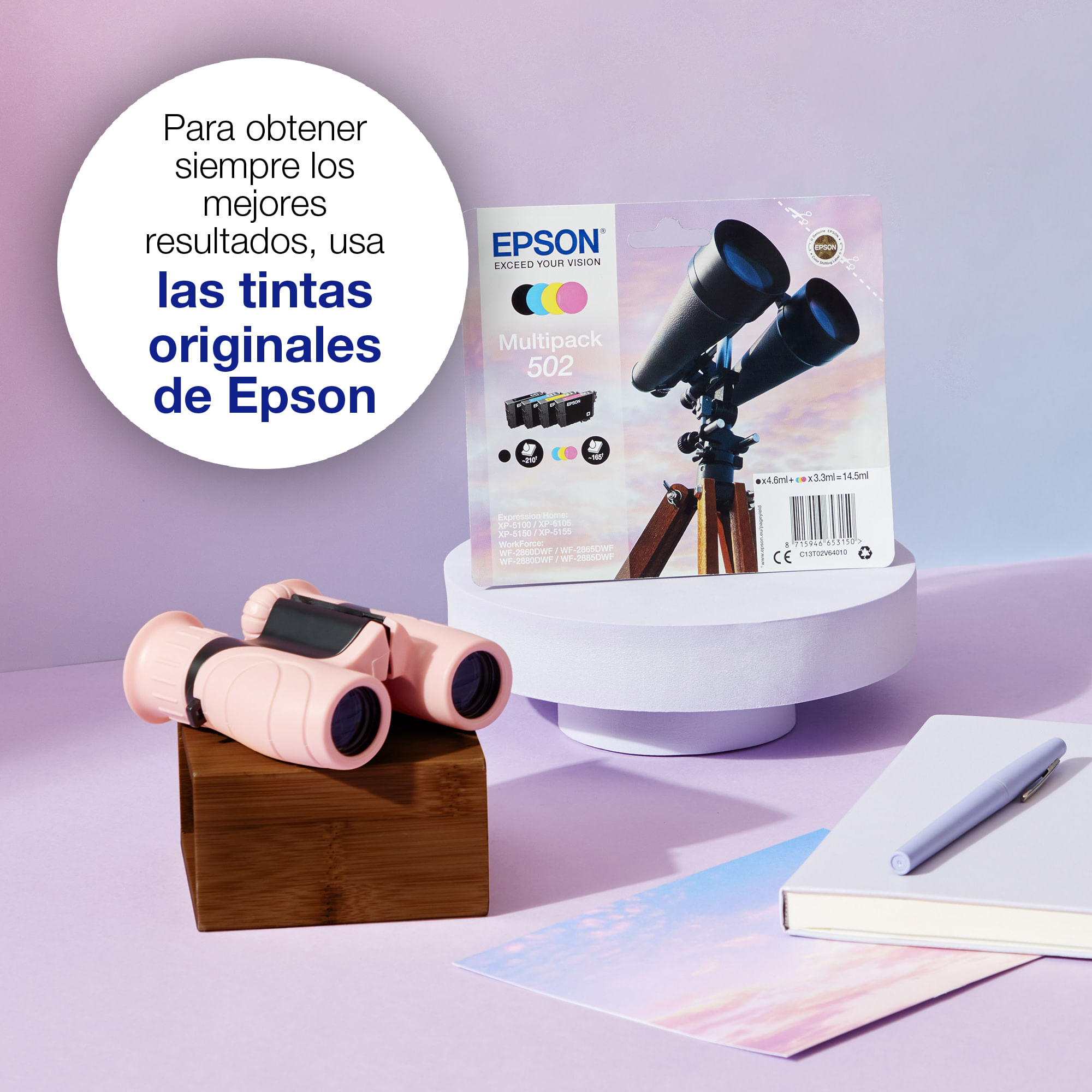 Różowa lornetka, tusz Epson 502 multipack, notatnik i długopis na fioletowym tle z hiszpańskim tekstem.