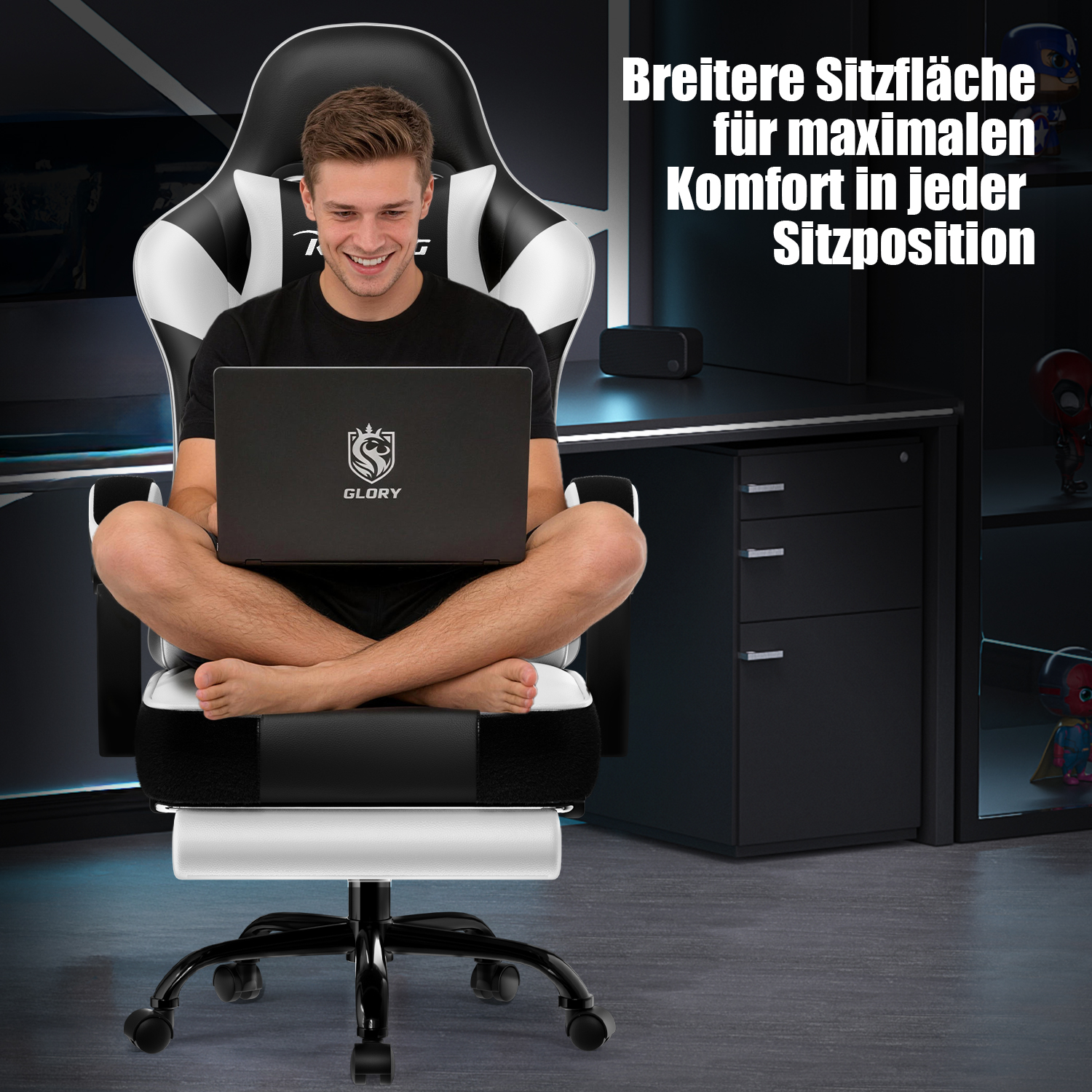 Mann sitzt im Schneidersitz mit Laptop auf einem breiten schwarz-weißen Gaming-Stuhl.