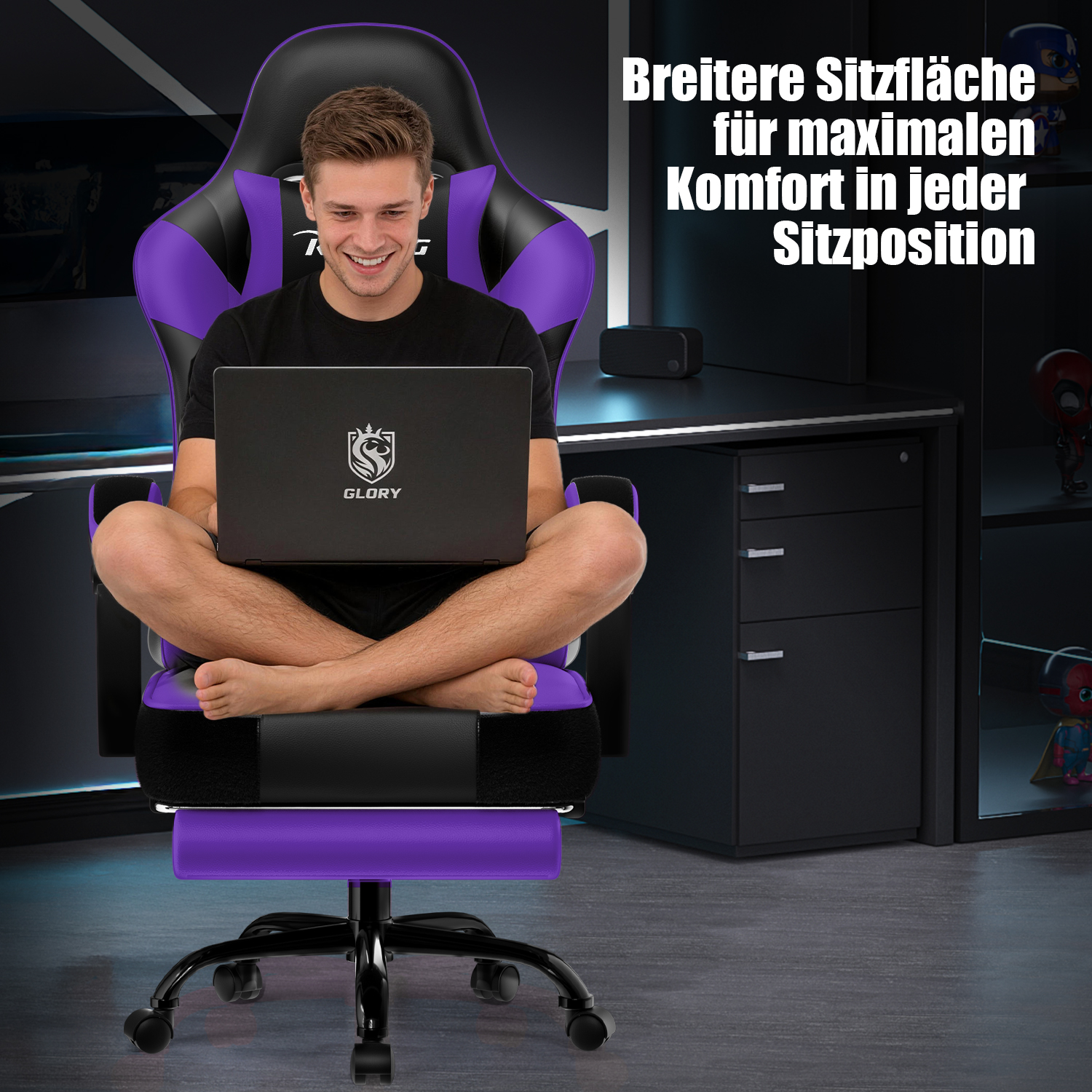 Ein lächelnder Mann sitzt mit überschlagenen Beinen in einem breiten, schwarz-lila Gaming-Stuhl und nutzt einen Laptop.