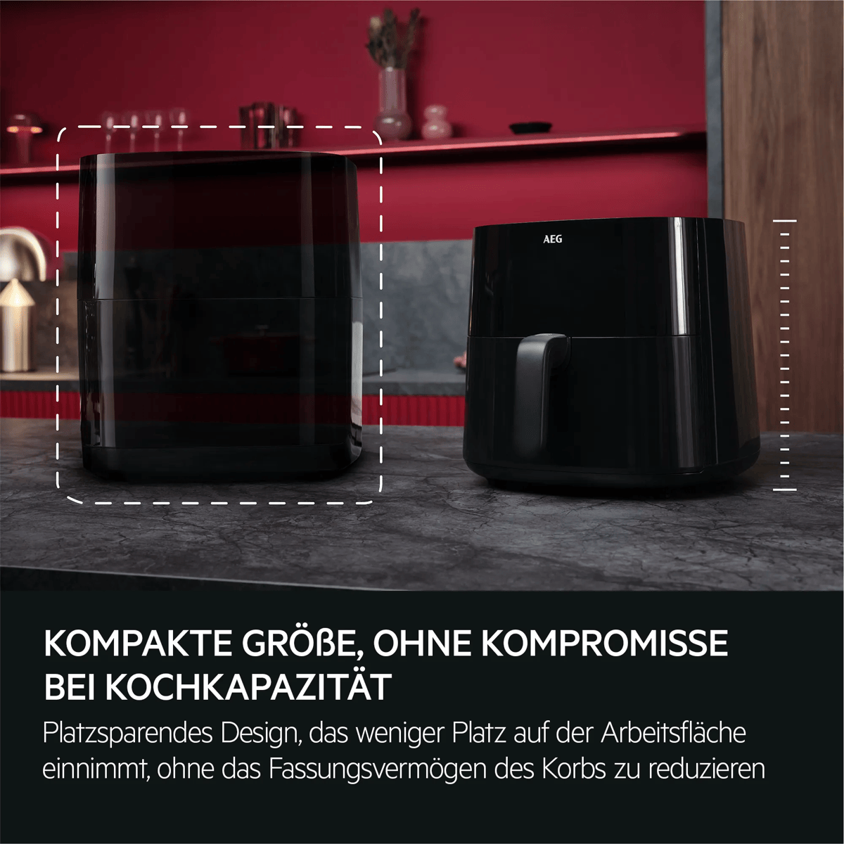 Dwie czarne frytkownice beztłuszczowe AEG na ciemnym blacie w kuchni z czerwoną ścianą.