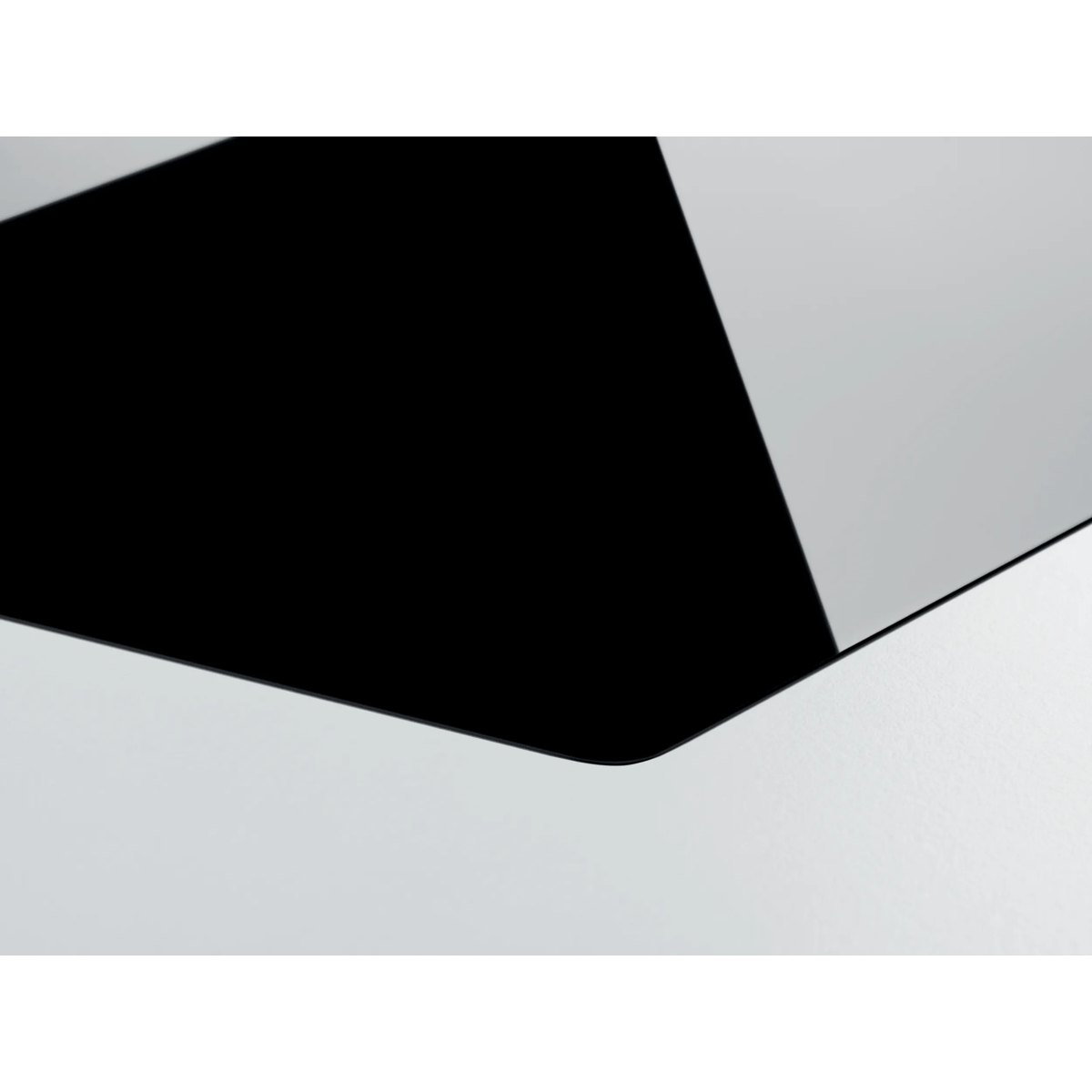 Primer plano de una superficie de vidrio negro brillante que contrasta con un fondo gris claro y líneas definidas.