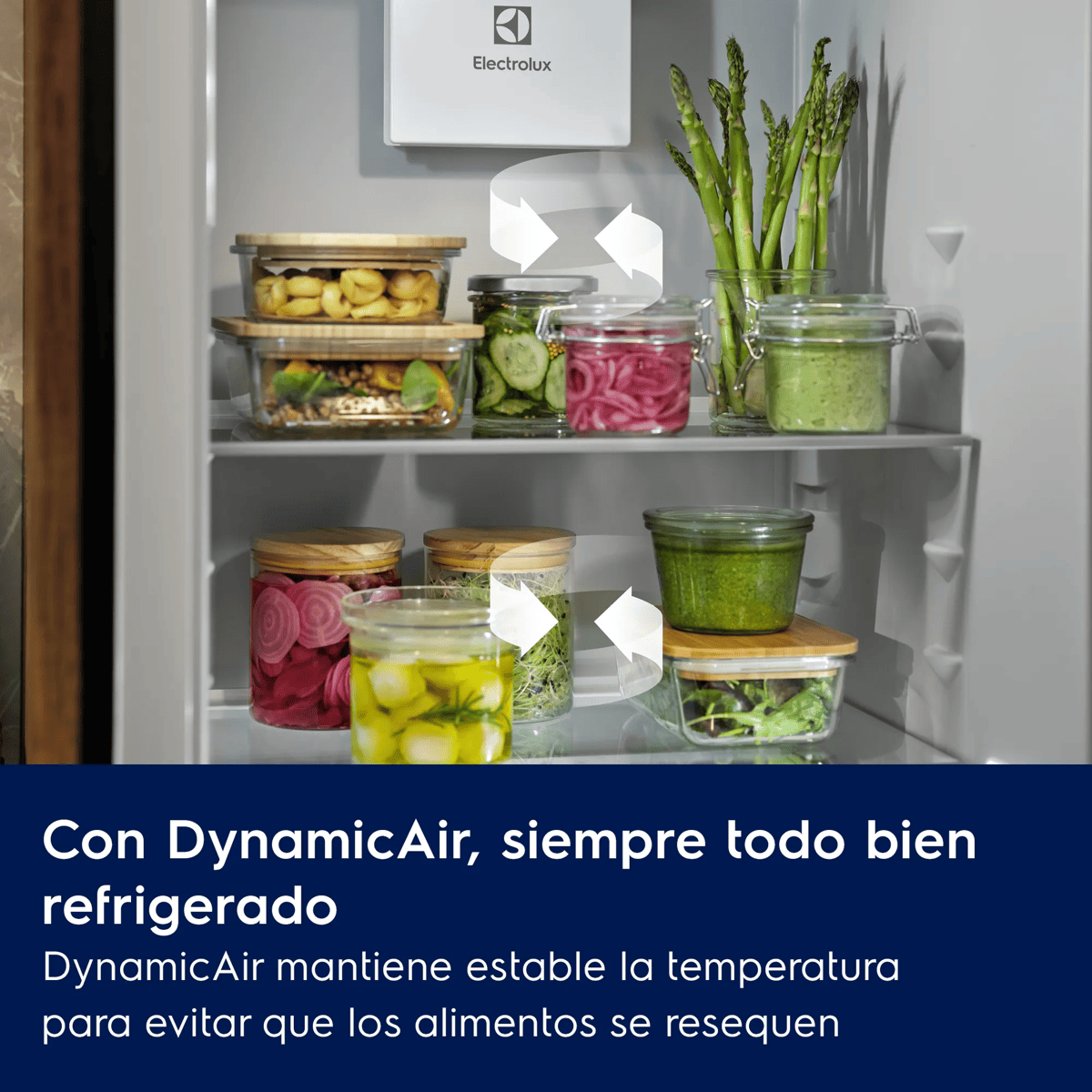 Vista interior de un refrigerador Electrolux con estantes llenos de frascos de vidrio con alimentos y espárragos.