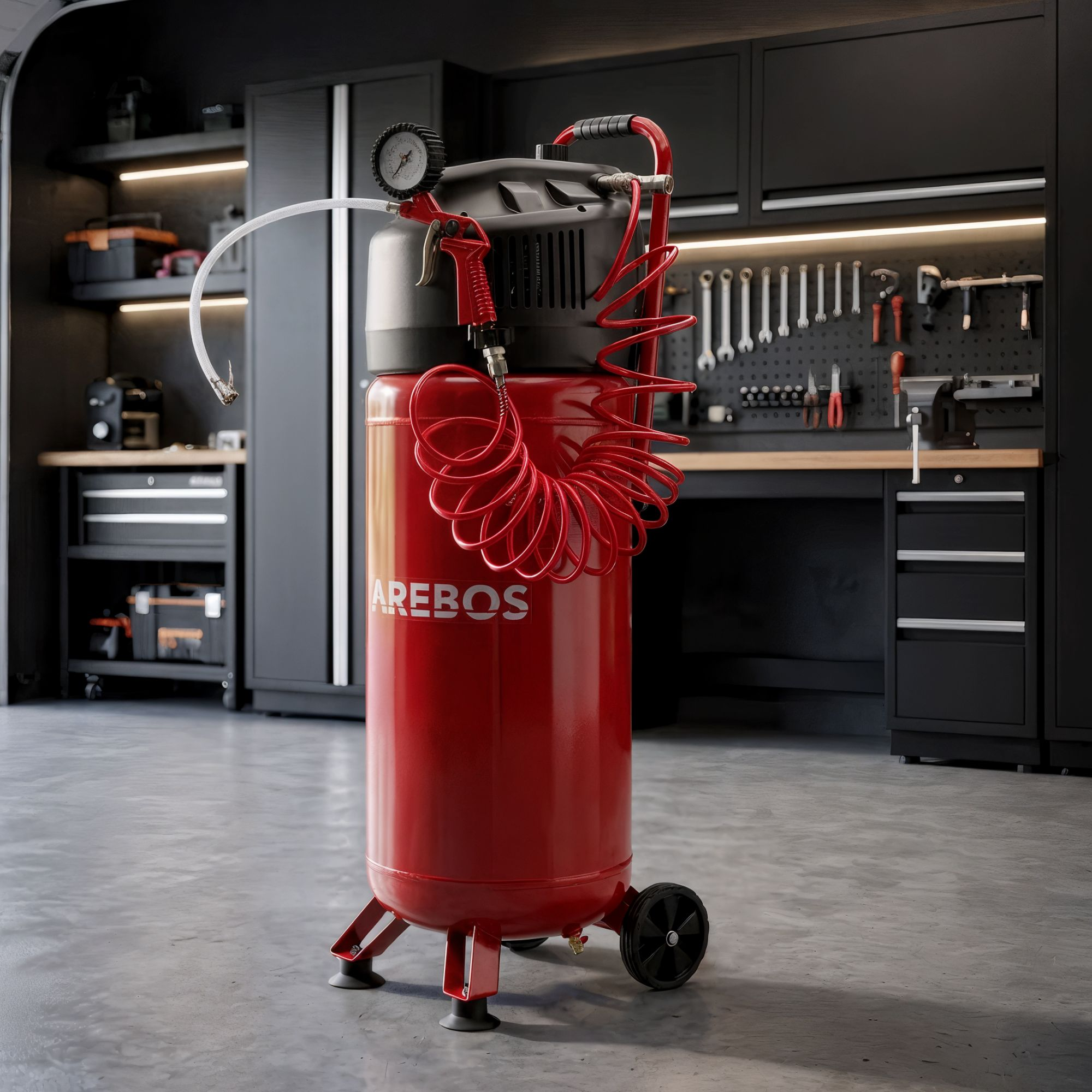 Ein roter AREBOS Druckluftkompressor mit rotem Spiralschlauch und schwarzen Rädern steht in einer Werkstatt.
