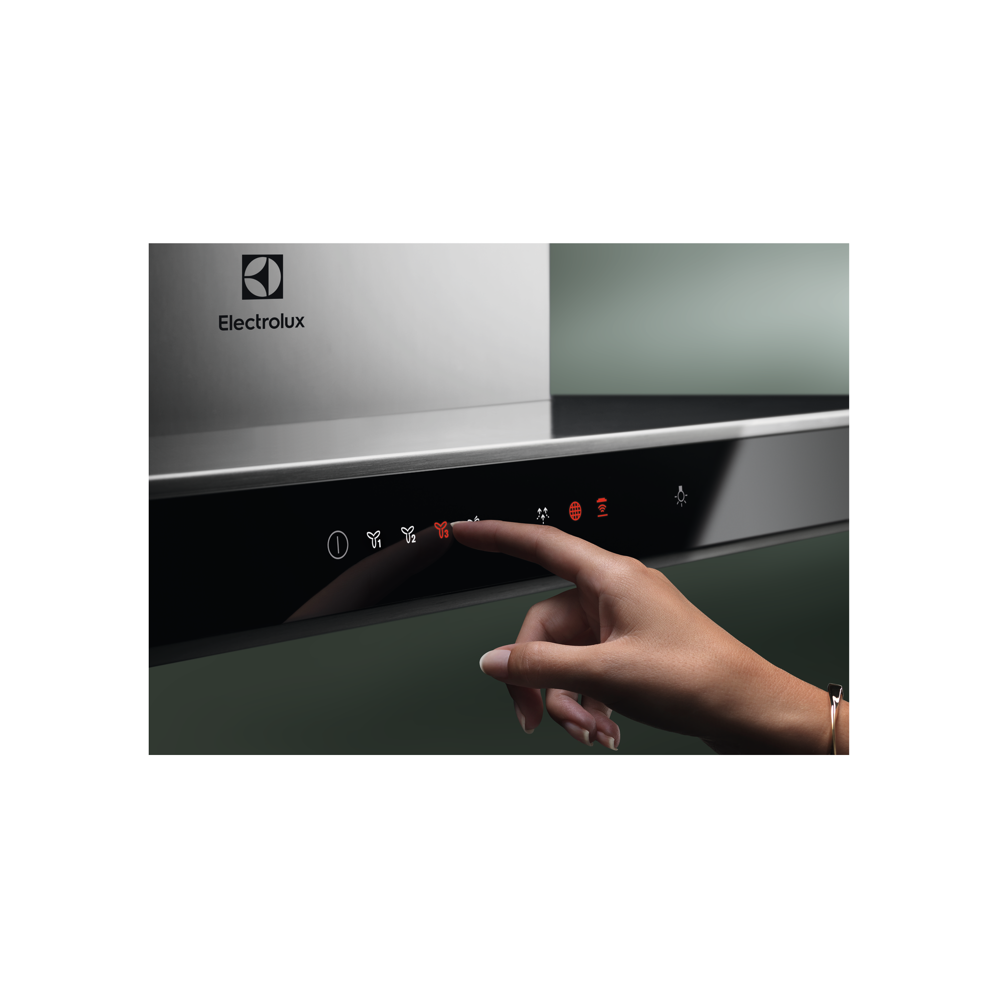 Una mano tocando el panel táctil de una campana extractora Electrolux con controles iluminados.