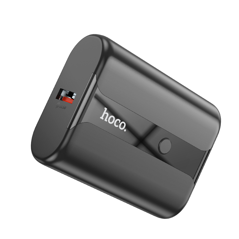 Un banco de energía Hoco negro con puerto USB y botón sobre fondo blanco.