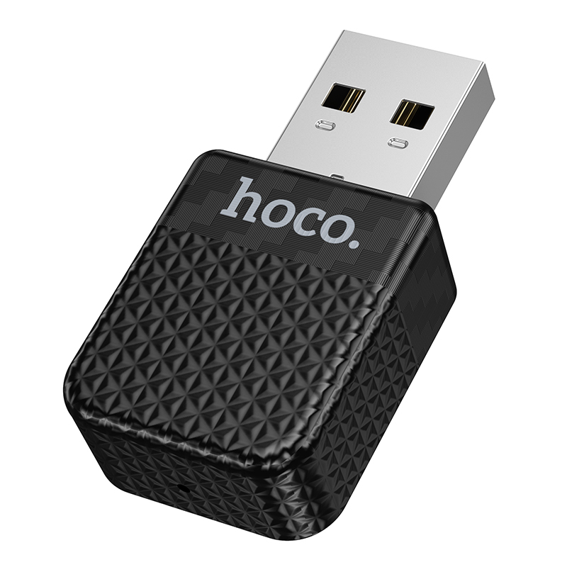 Un adaptador USB Hoco negro con patrón geométrico texturizado y conector USB plateado sobre fondo blanco.