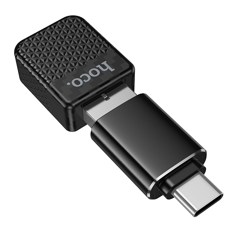Un adaptador USB hoco. negro con cuerpo texturizado y conector USB-C metálico sobre fondo blanco.
