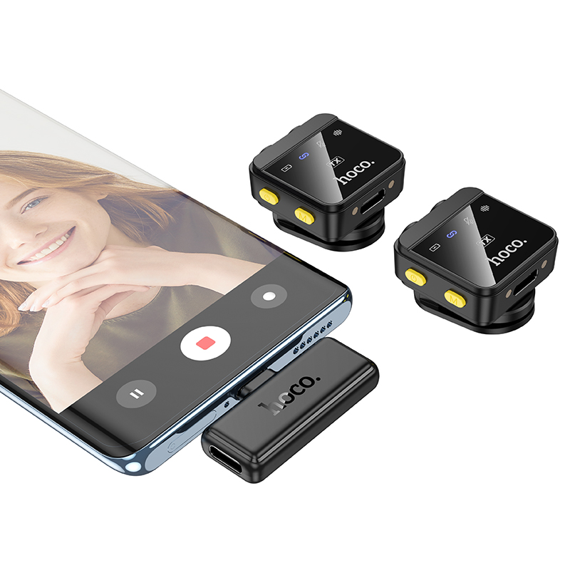 Un teléfono inteligente con una mujer sonriente, dos micrófonos inalámbricos de solapa y un receptor conectado.