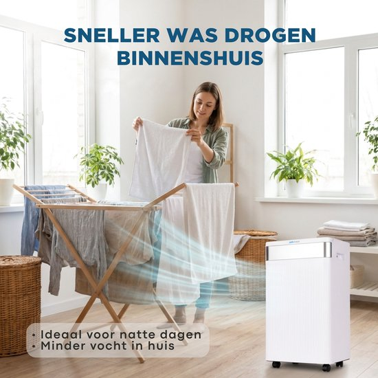 Frau hängt Wäsche auf, während ein weißer Luftentfeuchter im hellen Raum steht.